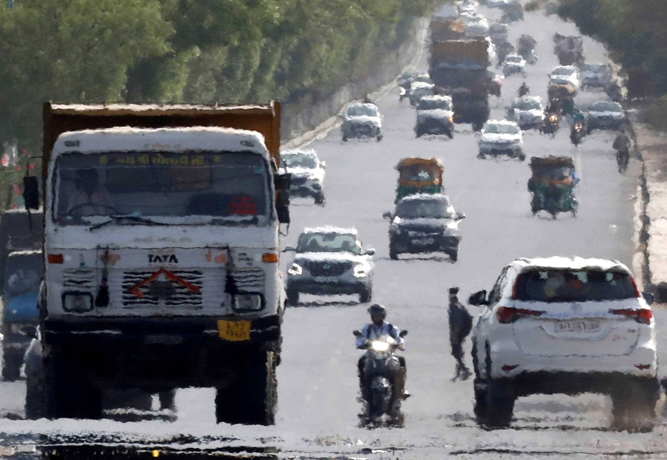 Traffic moves on a road in a heat haze during hot weather on the outskirts of Ahmedabad, India, May 12, 2022. Photo: Reuters
