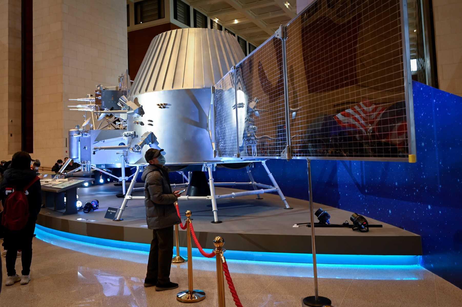 A man looks at a model of a lunar orbiter from China's lunar exploration program Chang'e-5 Mission during an exhibition at the National Museum of China in Beijing on March 4, 2021. Photo: AFP