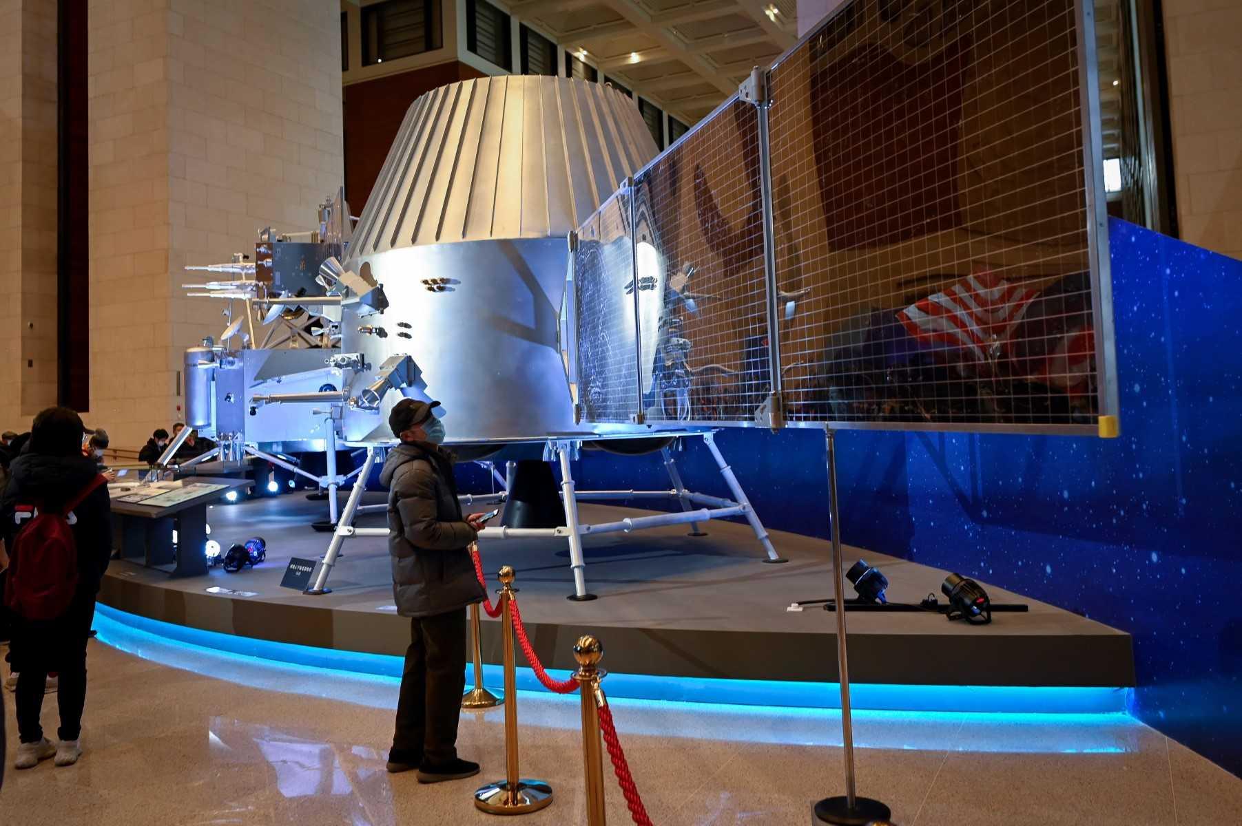 A man looks at a model of a lunar orbiter from China's lunar exploration program Chang'e-5 Mission during an exhibition at the National Museum of China in Beijing on March 4, 2021. Photo: AFP 