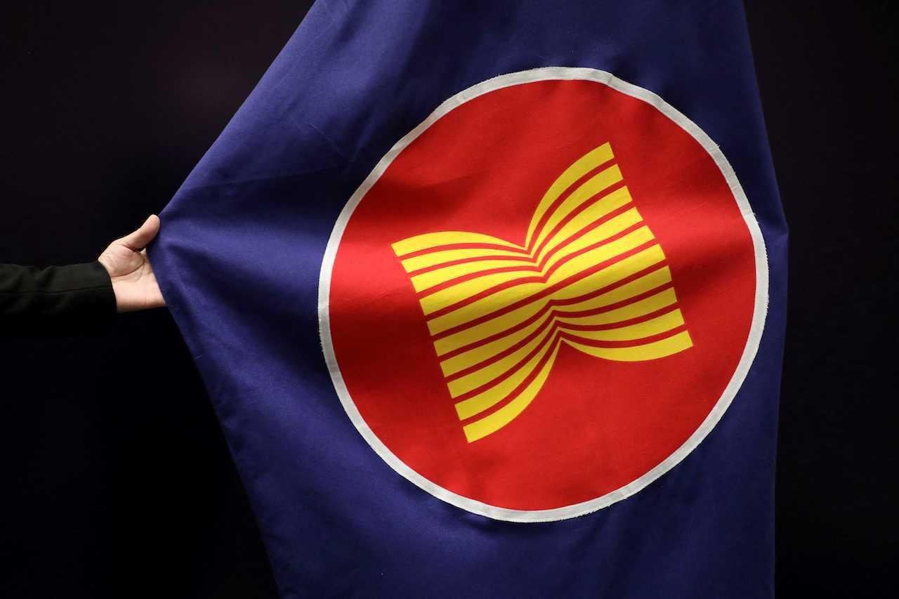 Seorang pekerja melaraskan bendera Asean di dewan mesyuarat di Kuala Lumpur, Malaysia, 28 Oktober 2021. Gambar: Reuters