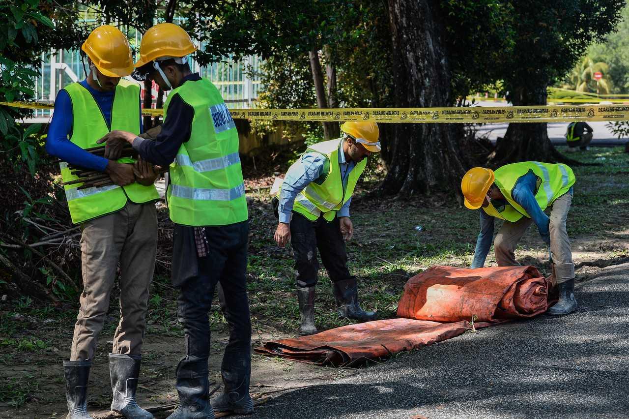 Contractors carrying out repair works following the landslide that struck the grounds of the Malaysian Anti-Corruption Academy yesterday. Photo: Bernama