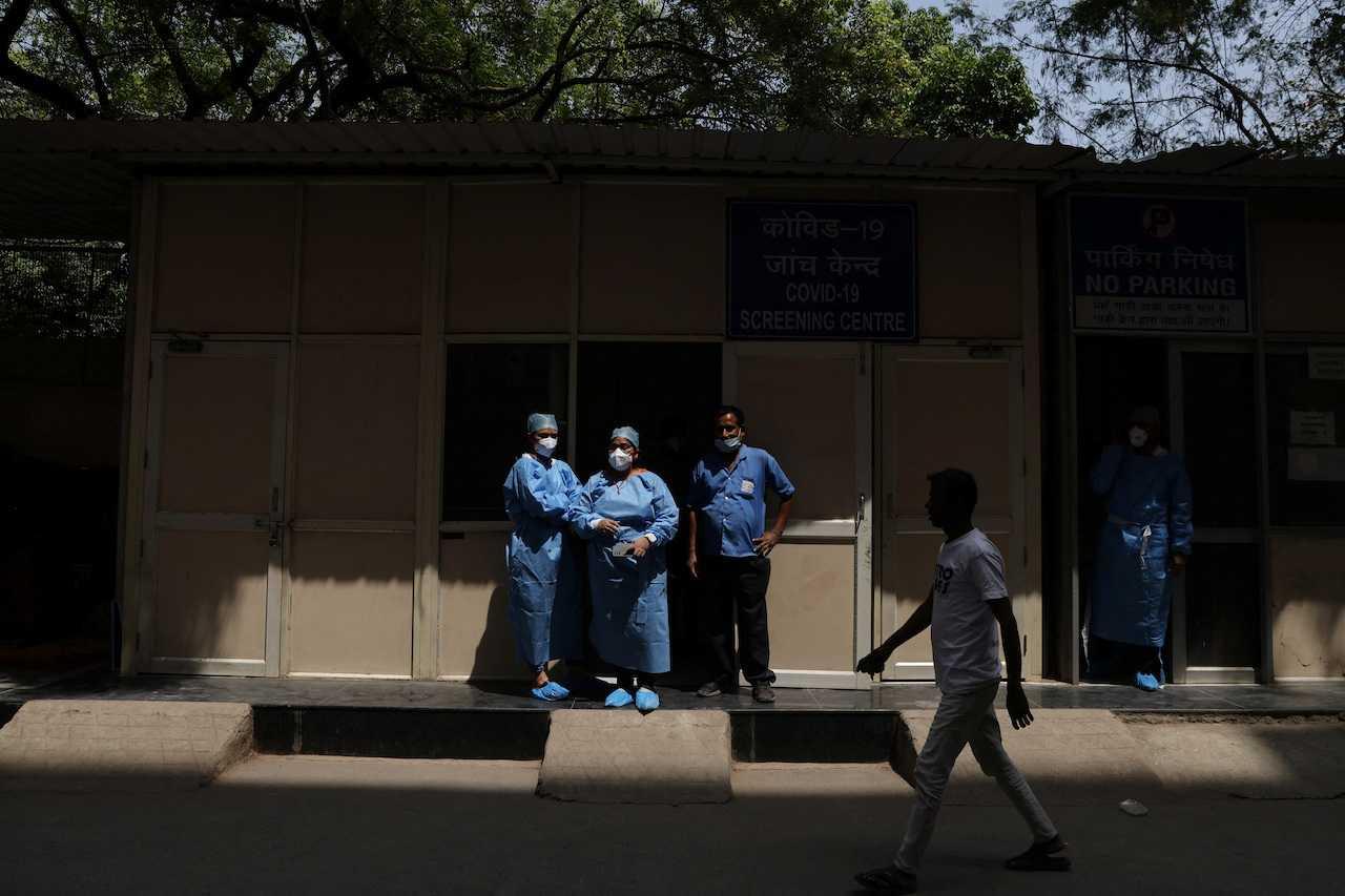 Healthcare workers wearing personal protective equipment stand outside a testing centre in a hospital as Covid-19 cases rise in the country, in New Delhi, India, April 10. Photo: Reuters