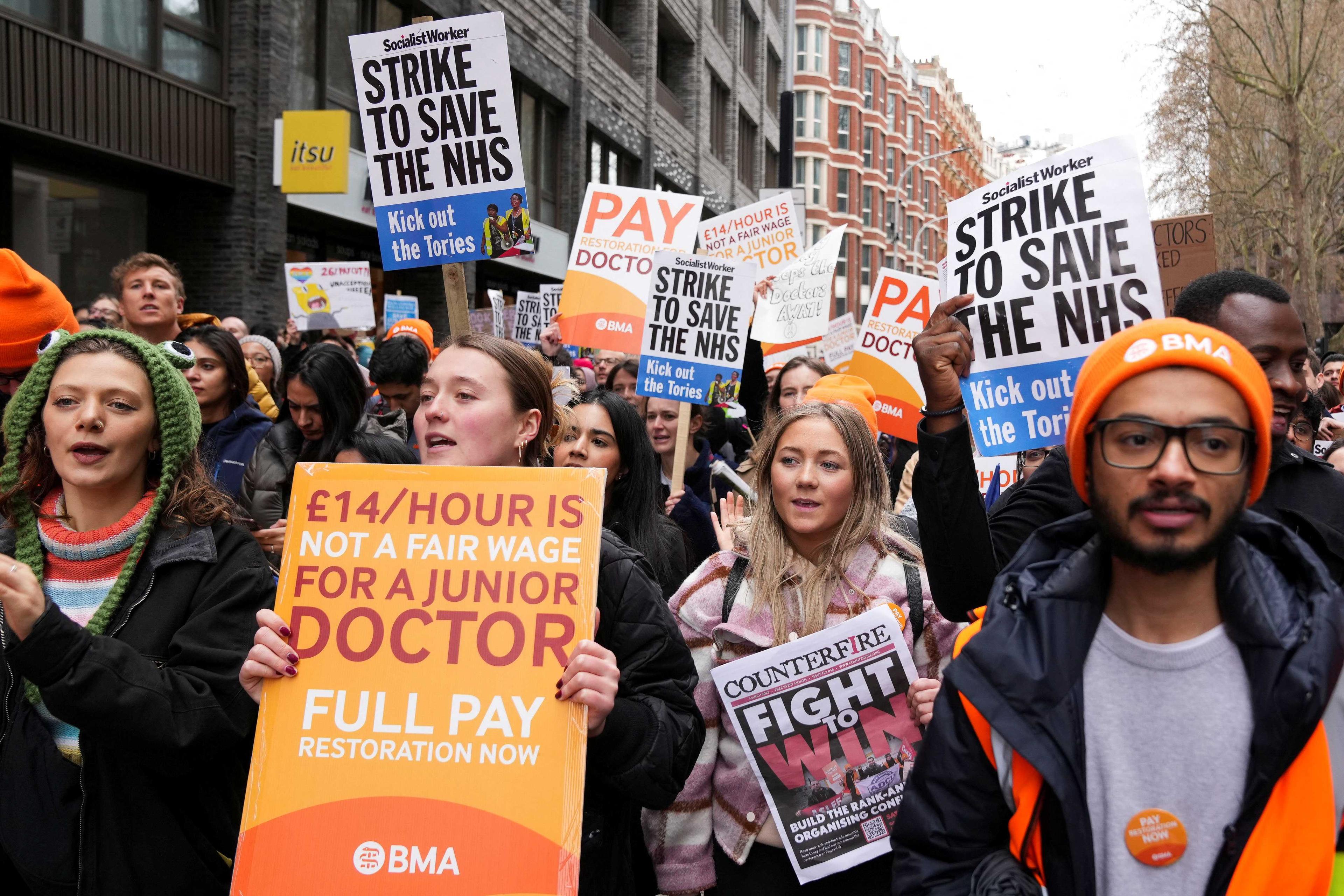 Doktor muda memegang sepanduk semasa mogok, di tengah-tengah pertikaian dengan kerajaan berhubung isu gaji, di London, Britain 11 April. Gambar: Reuters