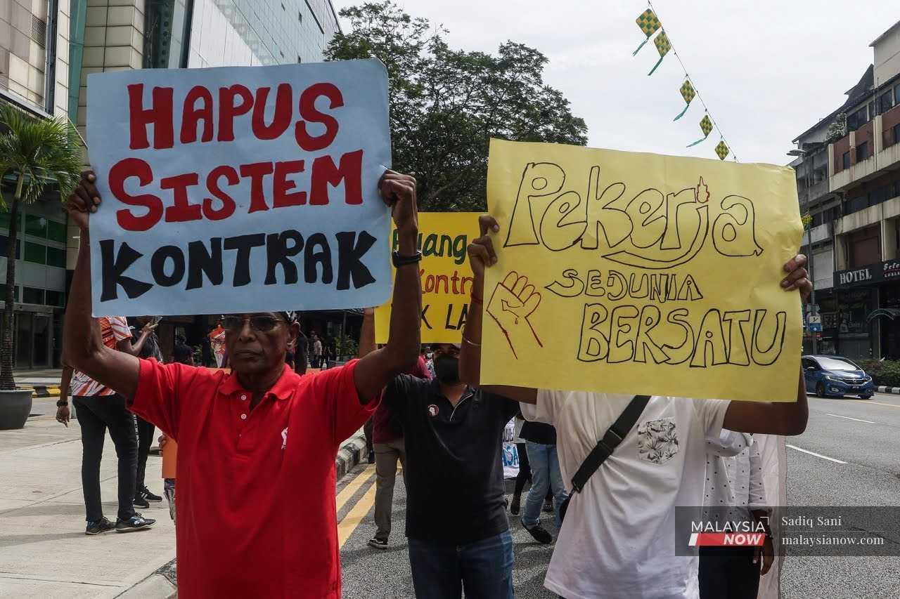Workers hold up placards as they walk towards Medan Pasar from Maju Junction in Kuala Lumpur for the Labour's Day march on May 1.