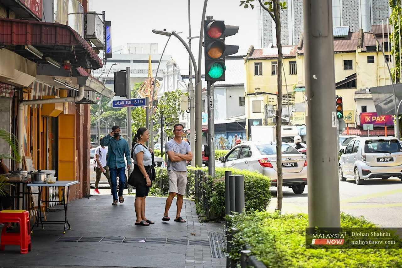Pedestrians wait to cross the road in Jalan Tun Tan Chen Lock in Kuala Lumpur. 