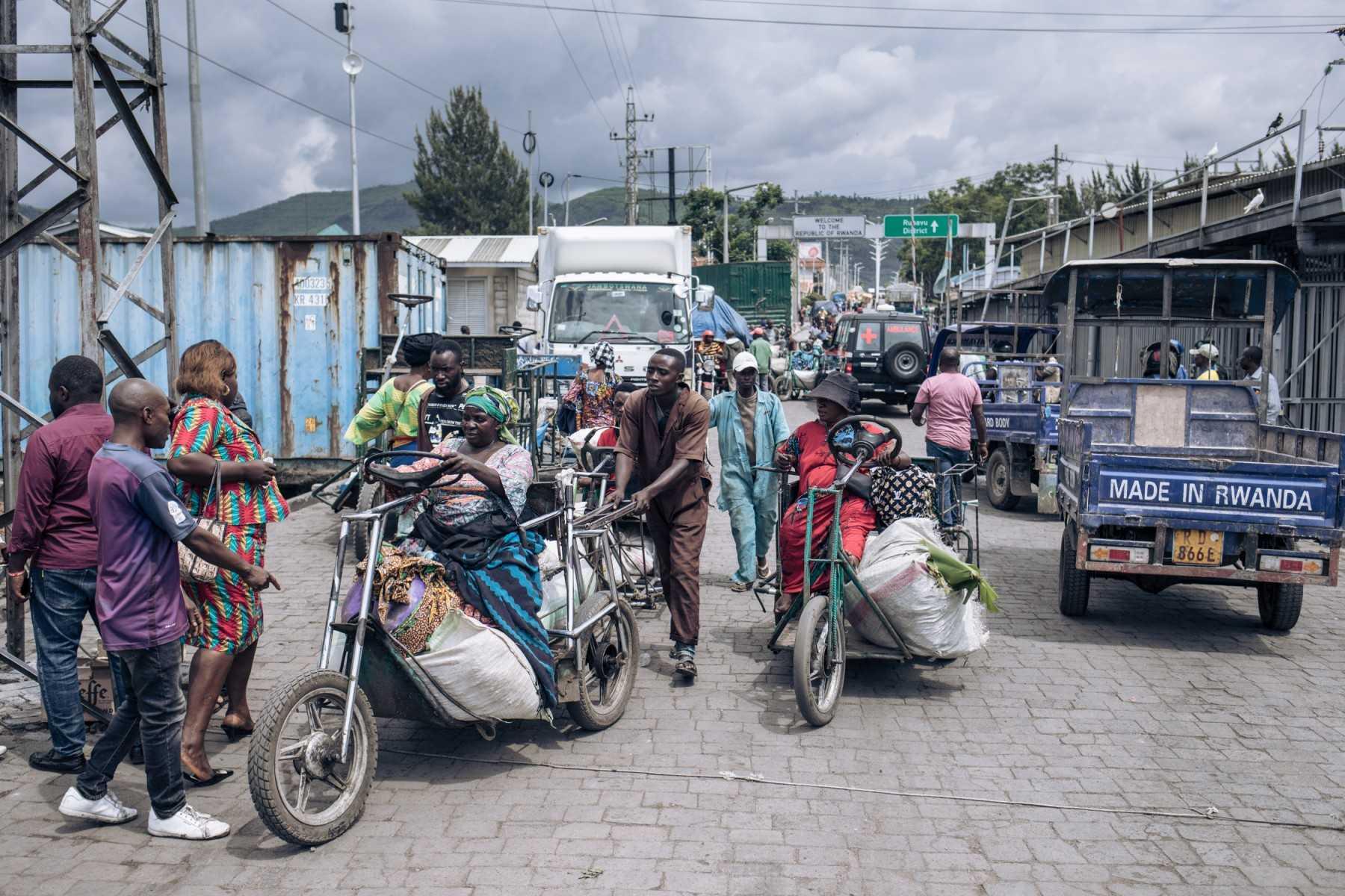 Traders on tricycles cross the border between Rwanda (in the background) and the Democratic Republic of Congo at the Petite Barrière border post in Goma on Nov 19, 2022. Photo: AFP