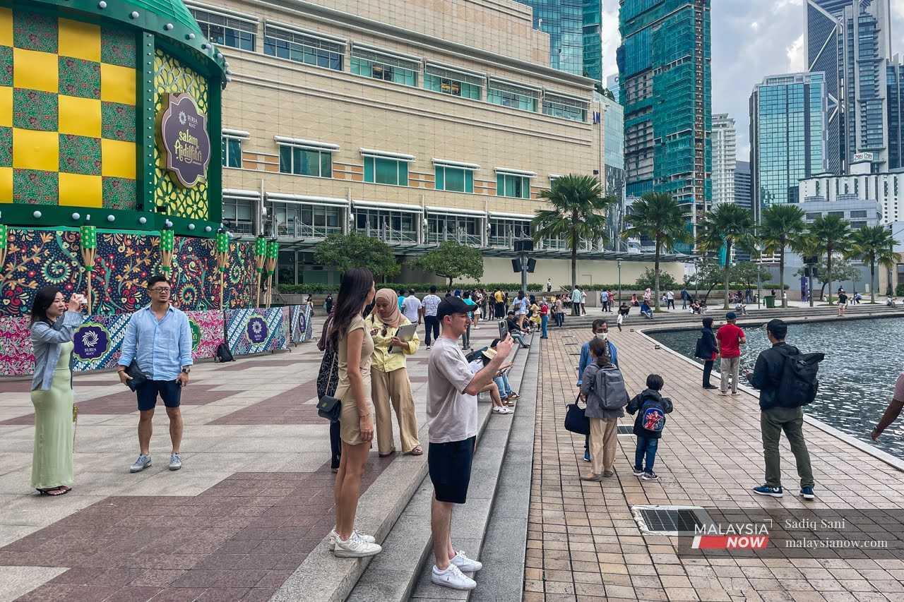 Beberapa pelancong dilihat mengambil gambar di pusat membeli belah KLCC, Kuala Lumpur, 2 Mei.