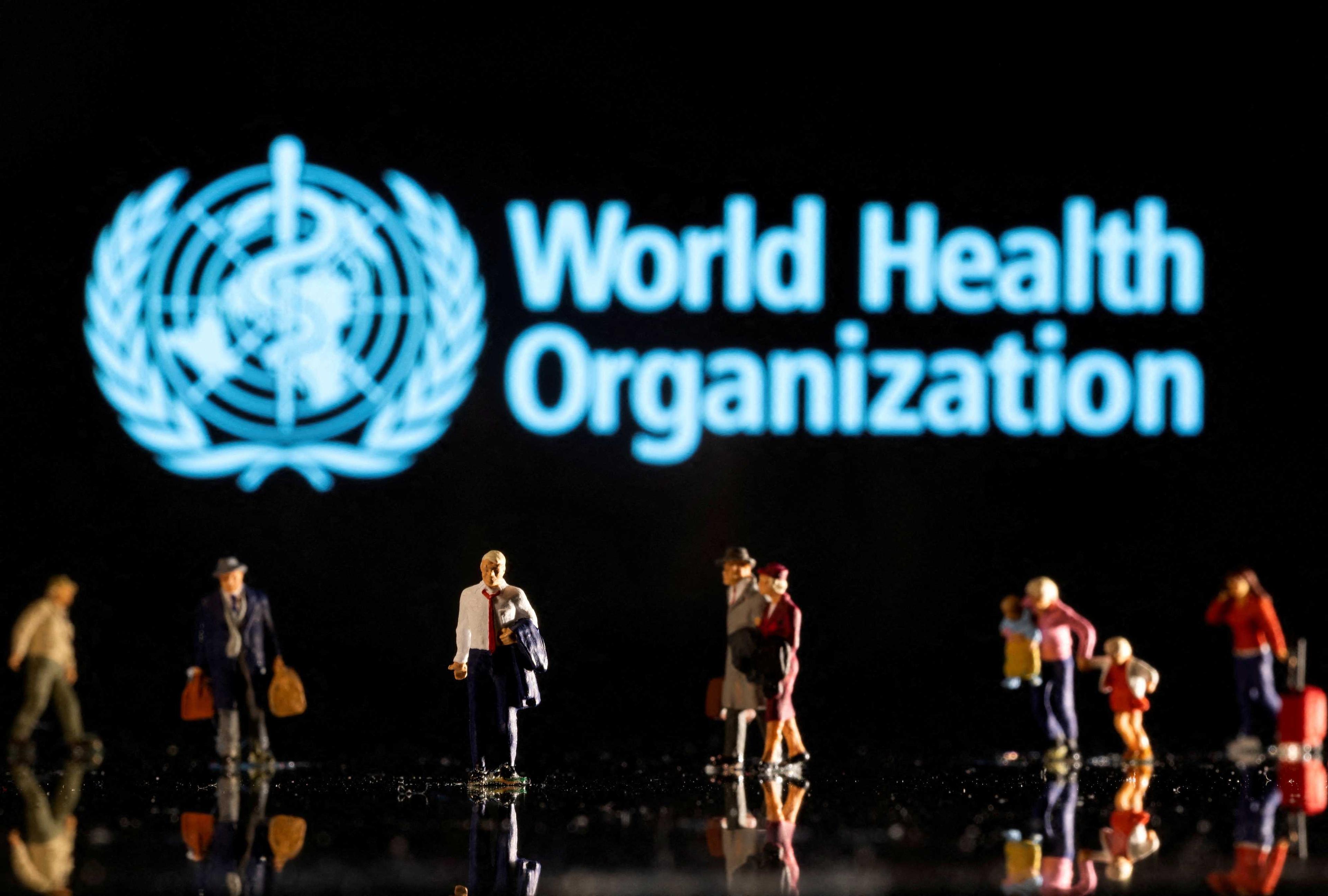 Figura kecil dilihat di hadapan logo Pertubuhan Kesihatan Sedunia yang dipaparkan dalam ilustrasi yang diambil pada 11 Februari 2022. Gambar: Reuters