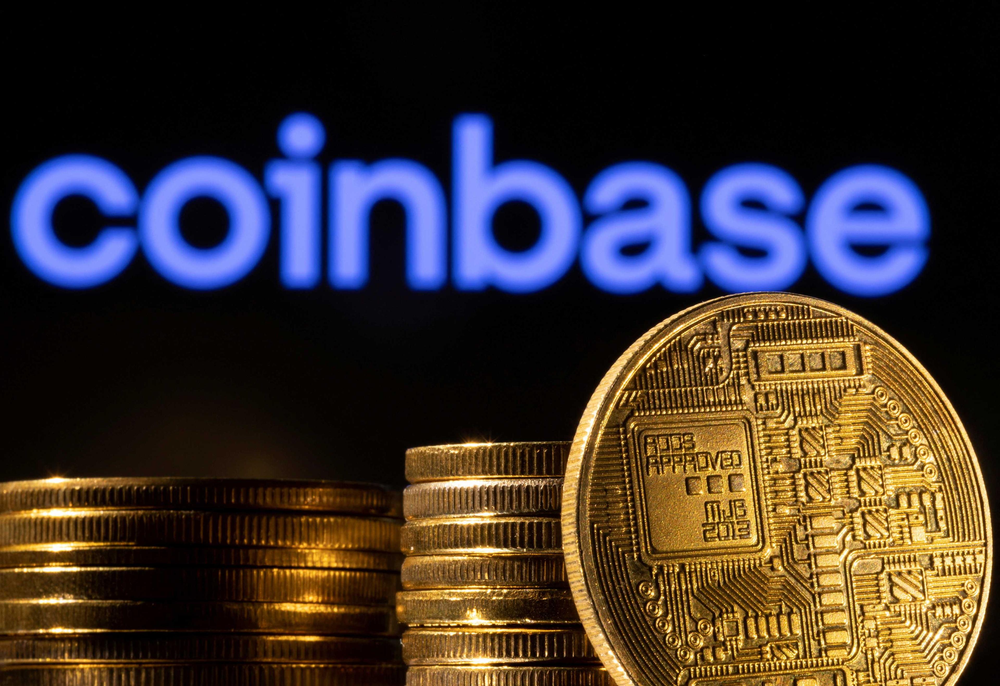 A representation of the cryptocurrency is seen in front of Coinbase logo in this illustration taken, March 4, 2022. Photo: Reuters