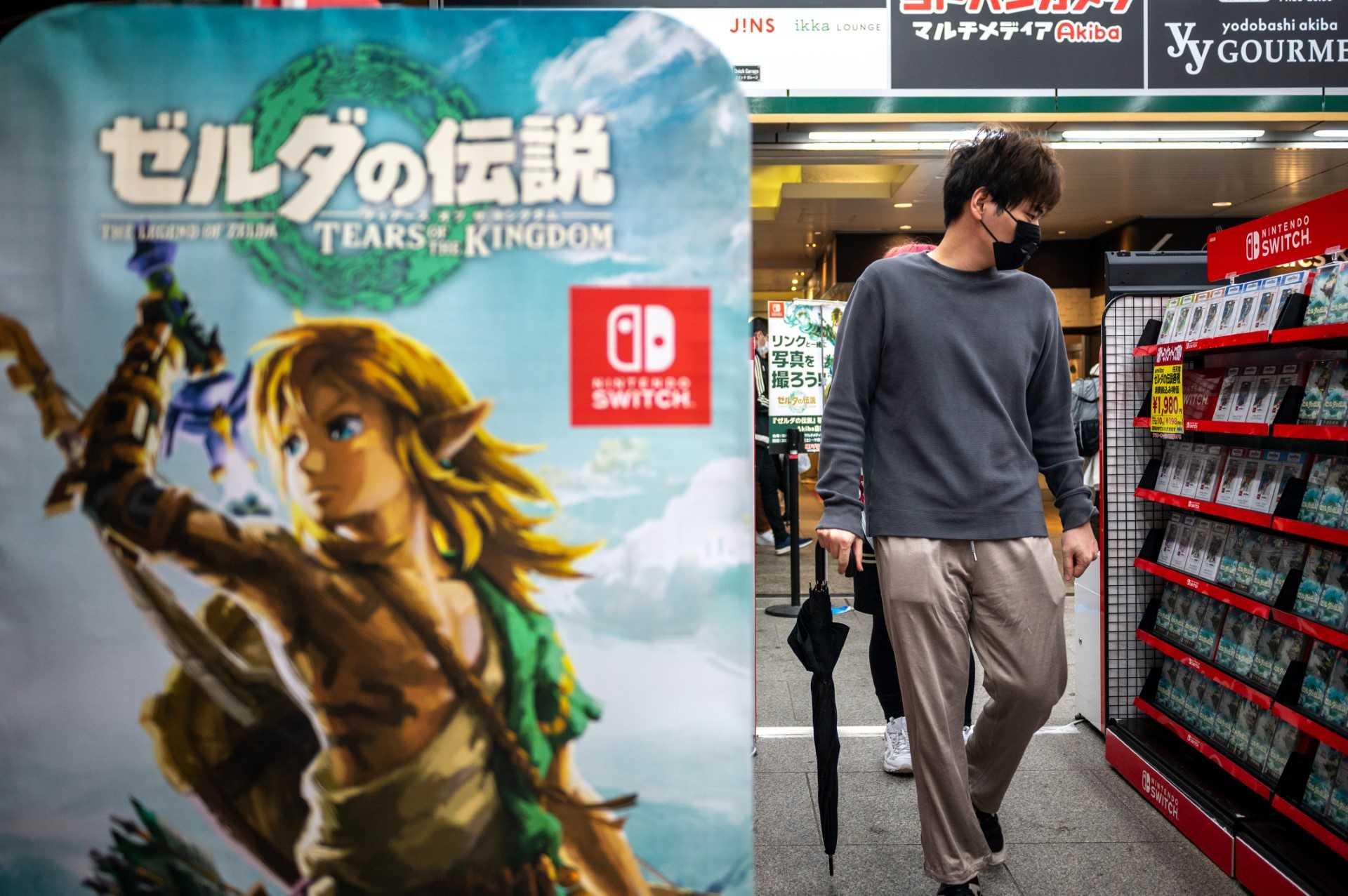 This picture taken on May 7, shows a visitor looking at a video game shelf next to a poster of Japanese gaming giant Nintendo's video game "The Legend of Zelda: Tears of the Kingdom", on display at a store in the Akihabara district of Tokyo. Photo: AFP