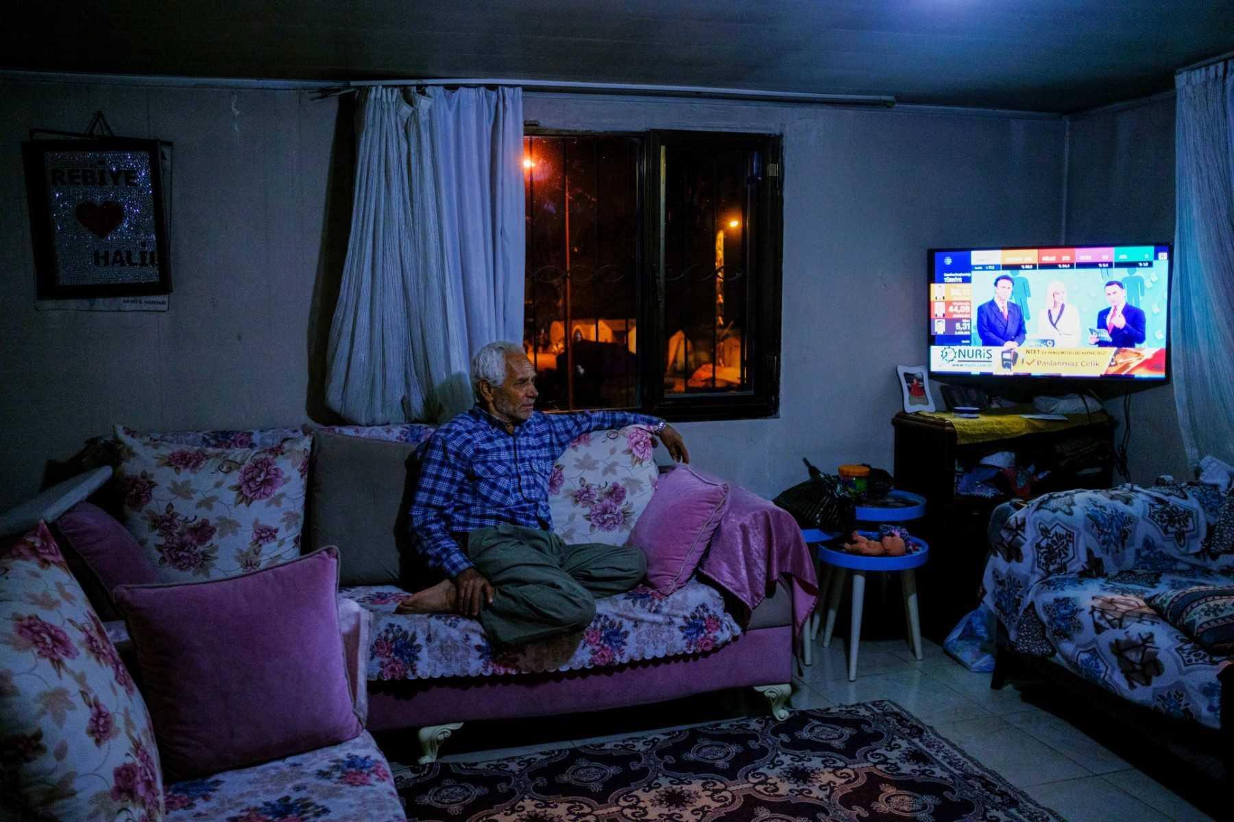 A quake-hit local resident follows election results at his damaged home following Turkey's devastating earthquake, in Hatay, on May 14. Photo: AFP