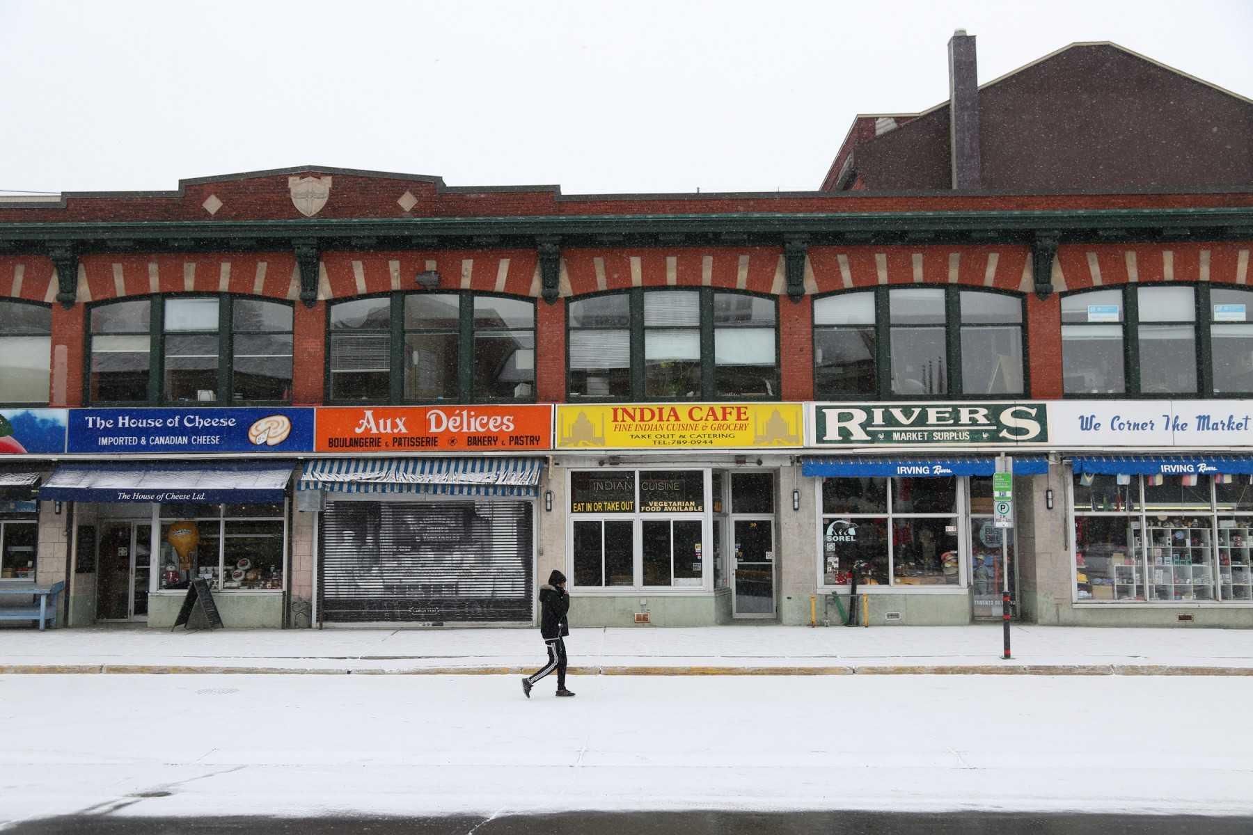 Seorang pejalan kaki berjalan di sepanjang jalan yang lengang dan kedai ditutup di Pasar Byward, Ottawa, Kanada, 23 Mac 2020. Gambar: AFP