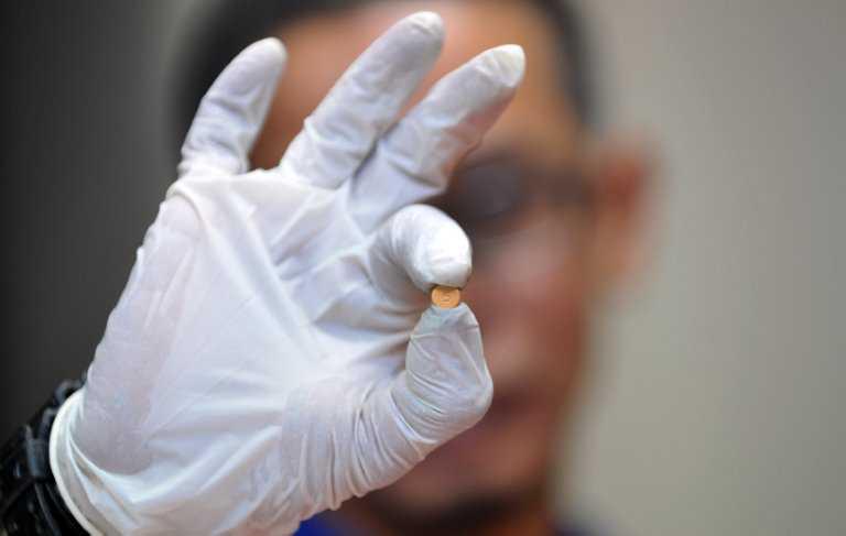 Seorang pegawai kastam menunjukkan pil Erimin 5 daripada dadah yang dirampas di ibu pejabat Kastam di bandar pelabuhan Klang pada 9 Julai 2012. Gambar: AFP