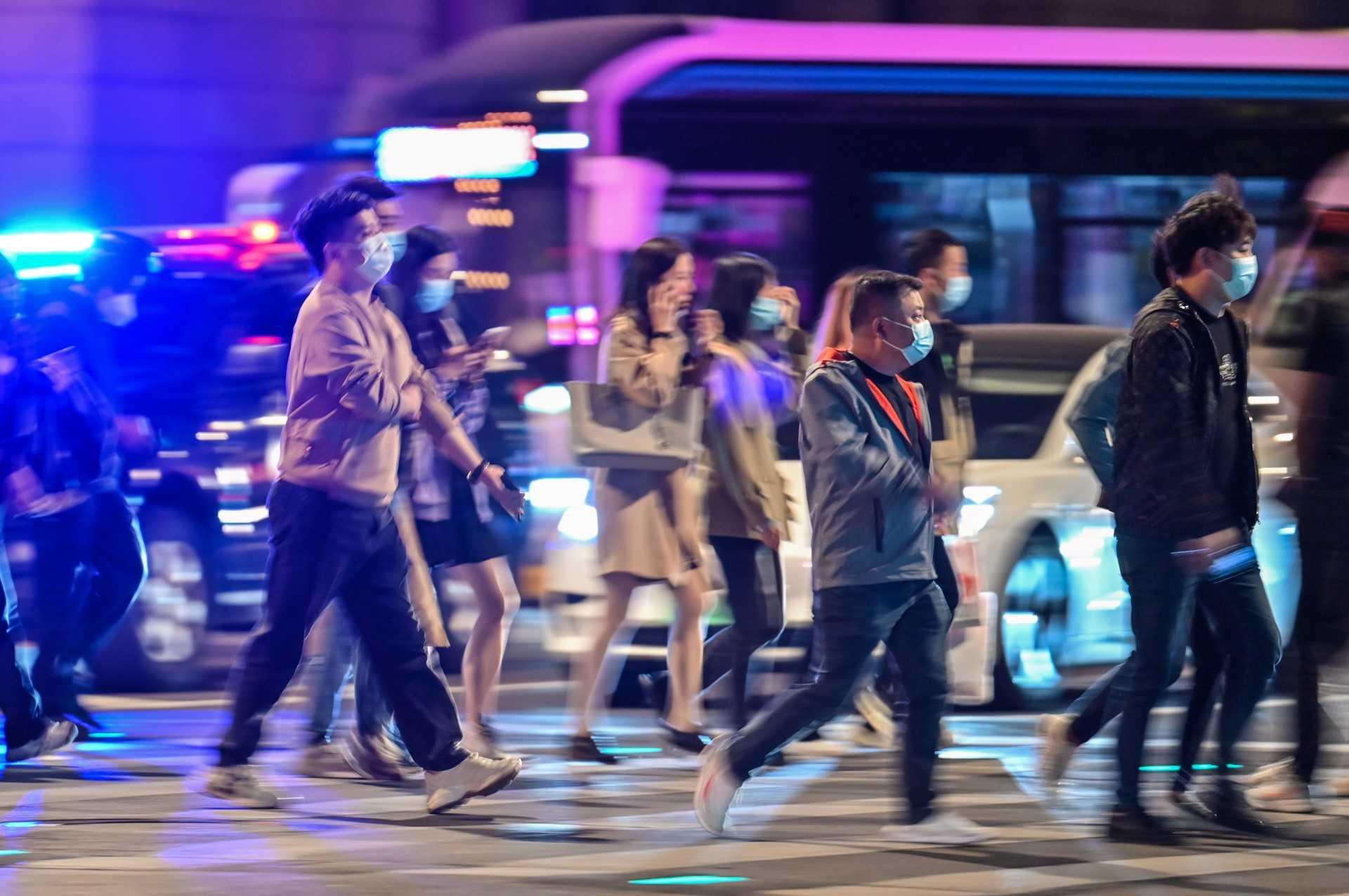 People cross a street on The Bund in Shanghai on Oct 24, 2022. Photo: AFP