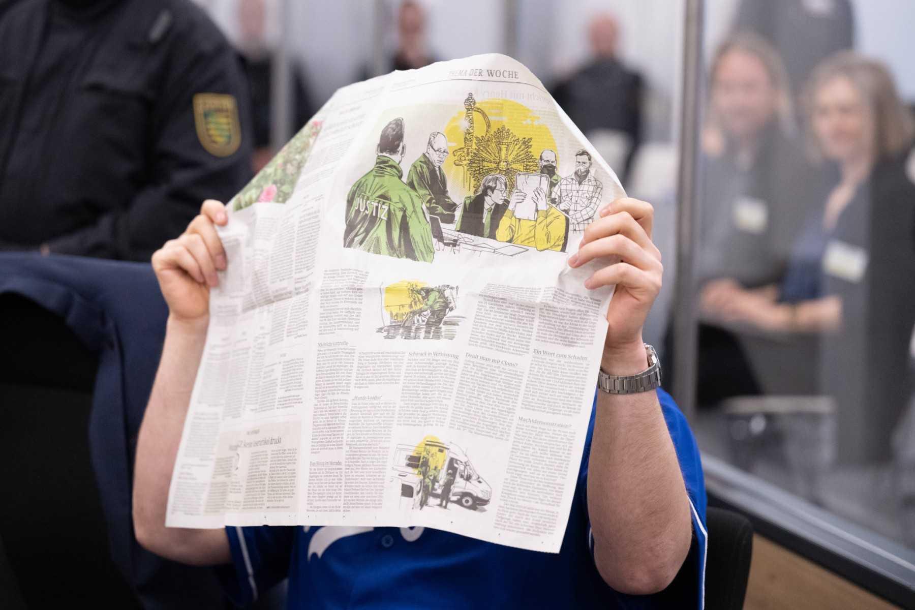 A defendant hides his face behind a newspaper reporting on his trial on May 16, at the Higher Regional Court in Dresden, eastern Germany. Photo: AFP 