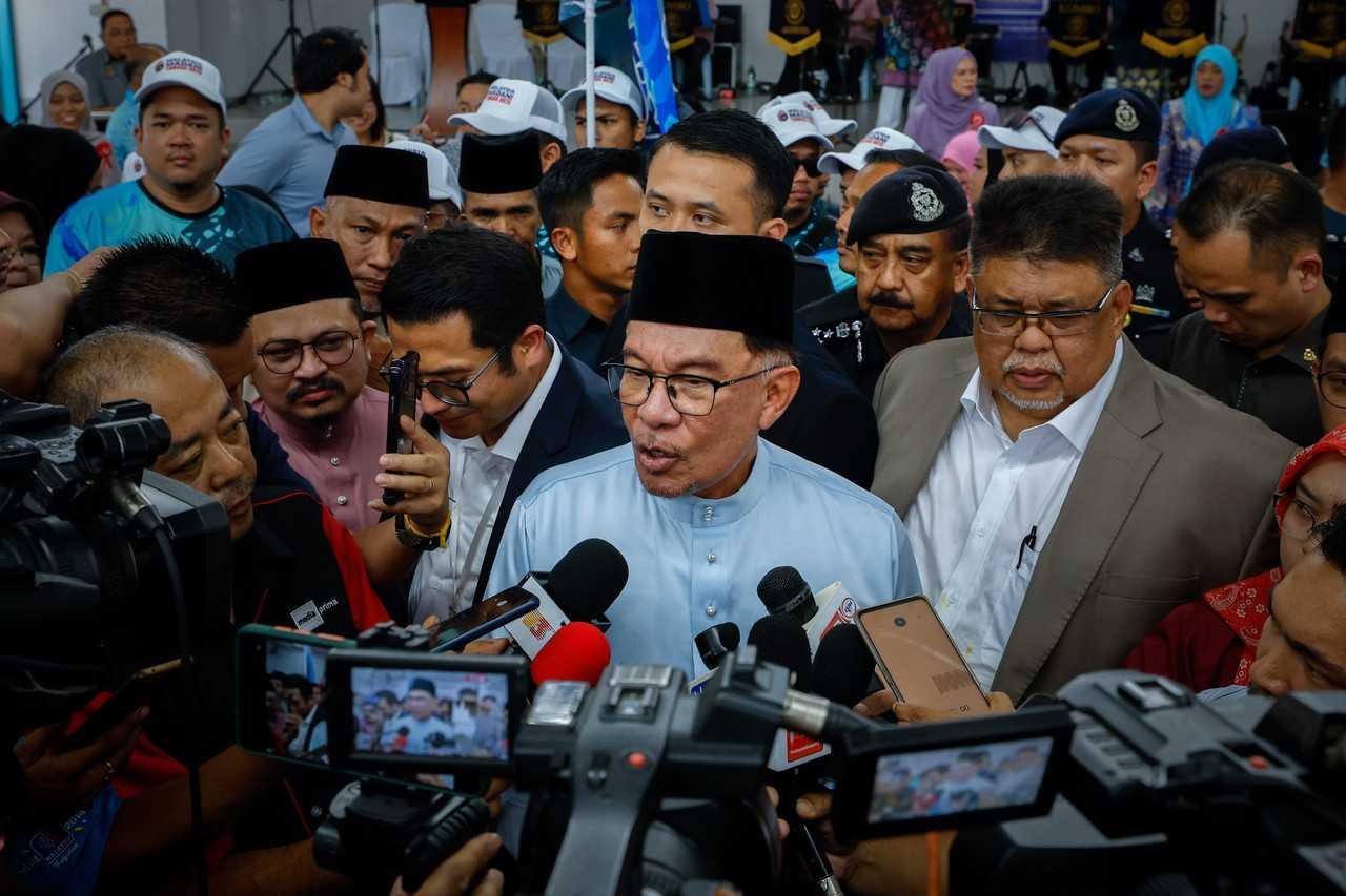 Perdana Menteri Anwar Ibrahim (dua dari kanan) semasa sidang media pada majlis Sambutan Aidilfitri Madani, Masyarakat bersama polis peringkat Parlimen Tangga Batu di Tanjung Minyak, 16 Mei.