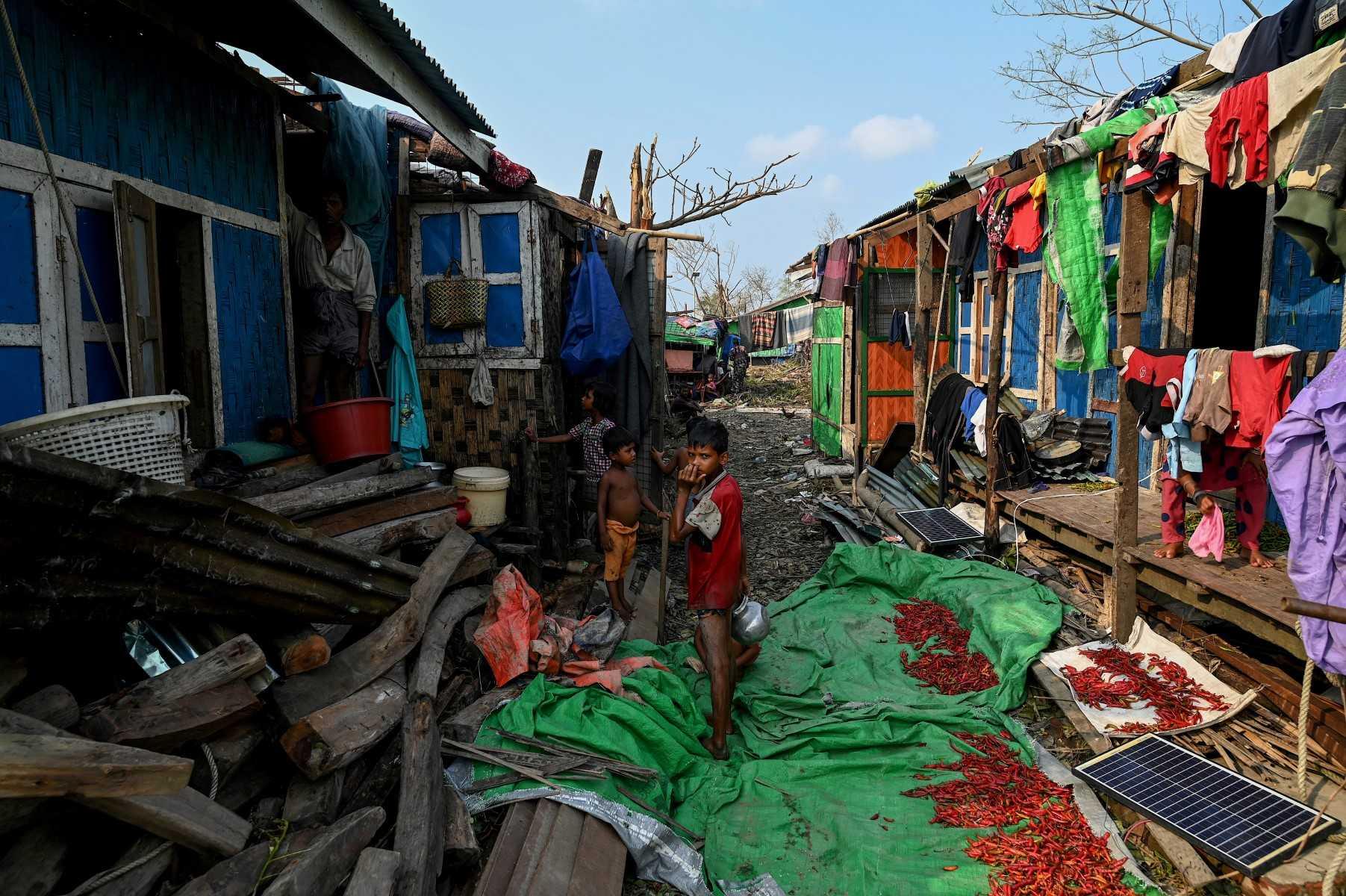 Rohingya children stand by destroyed houses at the Ohn Taw Chay refugee camp in Sittwe on May 16, in the aftermath of Cyclone Mocha's landfall. Photo: AFP