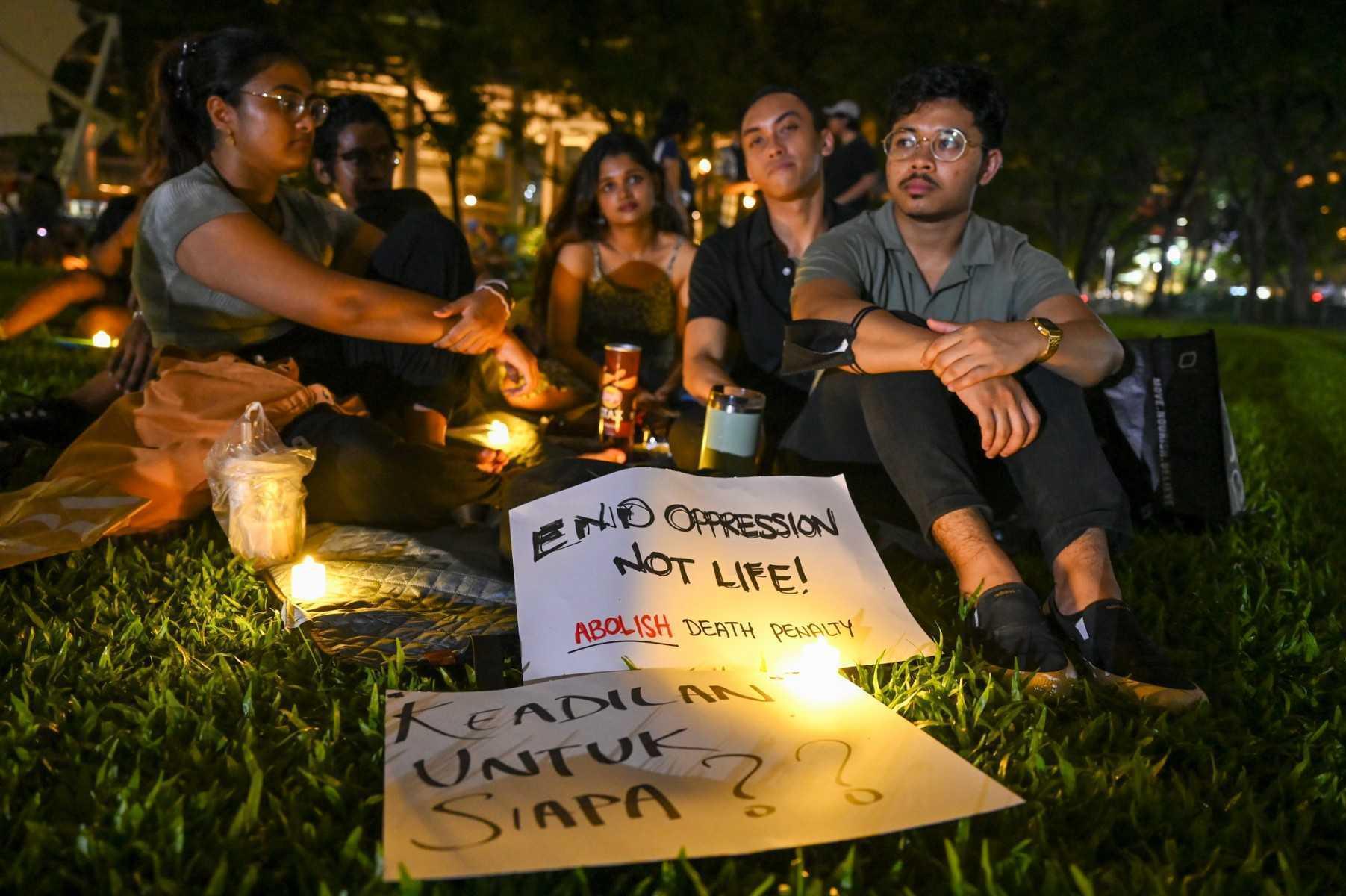 People display placards and LED lights during a vigil for Malaysian Nagaenthran K Dharmalingam, sentenced to death for trafficking heroin into Singapore, at Speakers corner in Singapore ahead of his execution, on April 25, 2022. Photo: AFP 