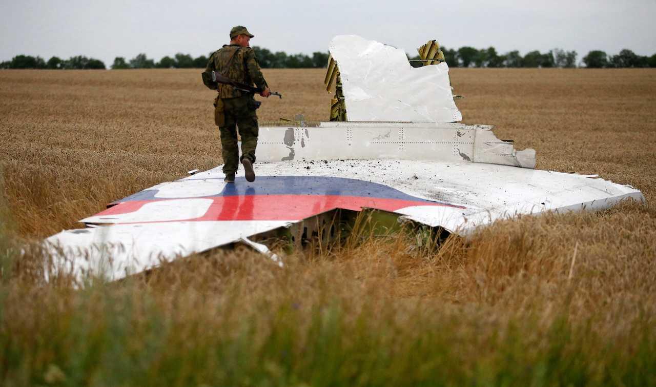 An armed pro-Russian separatist stands on part of the wreckage of Malaysia Airlines flight MH17 after it crashed near the settlement of Grabovo in the Donetsk region, July 17, 2014. Photo: Reuters