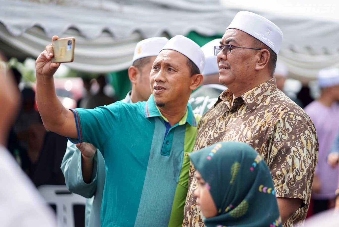 Kedah Menteri Besar Muhammad Sanusi Md Nor poses for a selfie with a guest at an open house in April. Photo: Facebook 