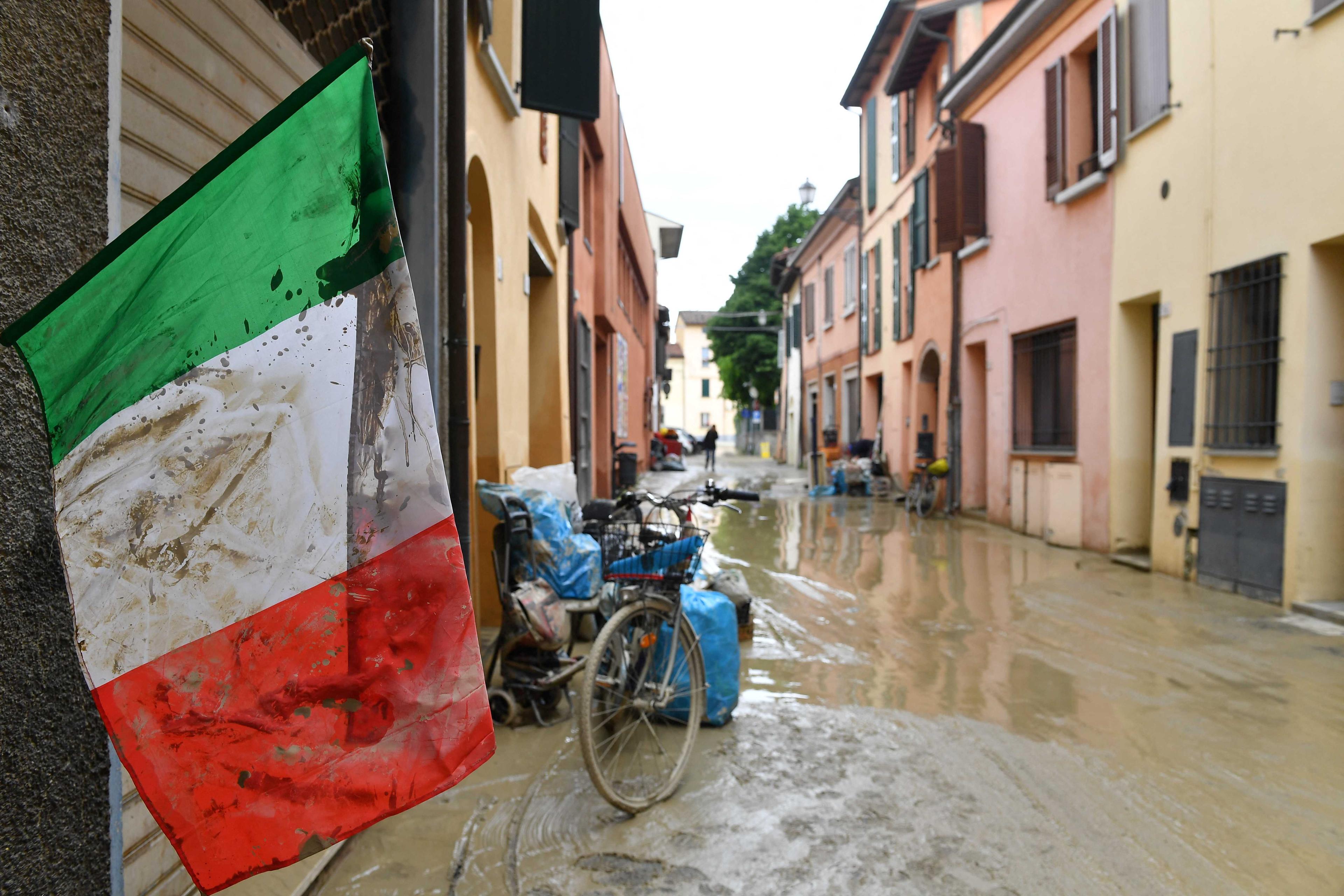An Italian flag covered in mud flutters on a flooded street, after heavy rains hit Italy's Emilia Romagna region, in Castel Bolognese, Italy, May 18. Photo: Reuters