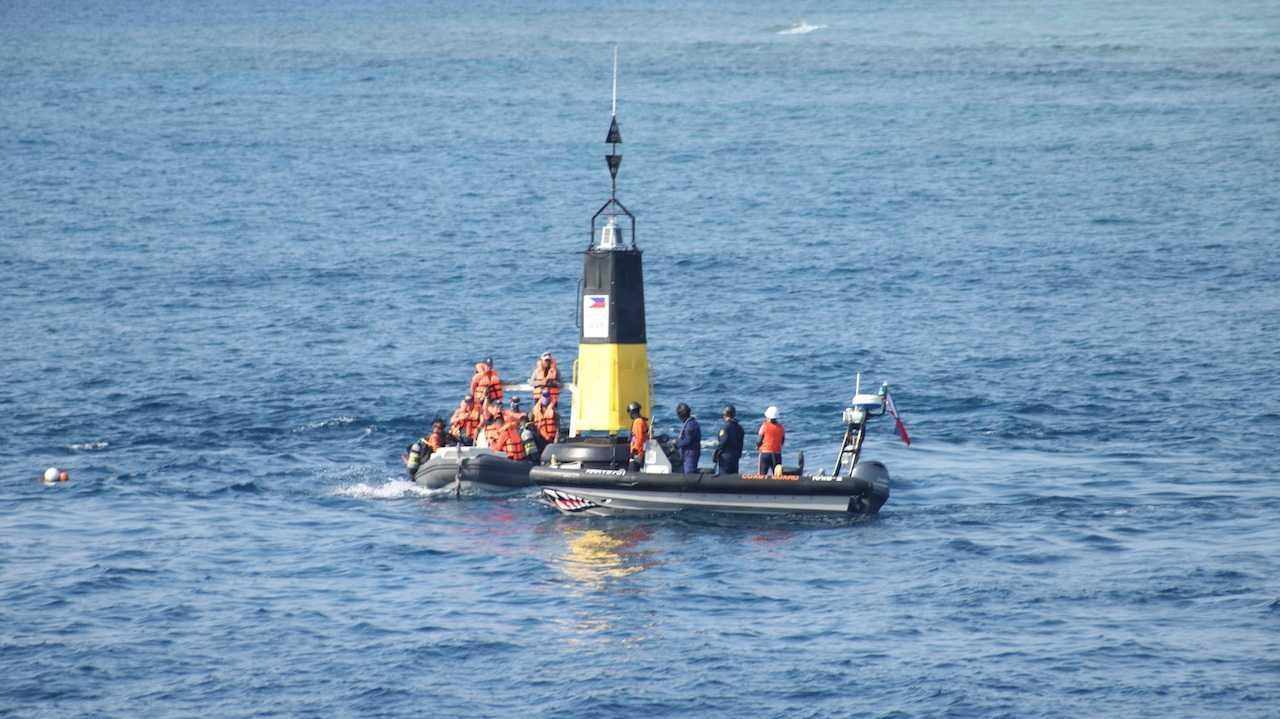Philippine Coast Guard members install navigational buoys in the Philippines' exclusive economic zone in the South China Sea, in this handout image obtained on May 15. Photo: Reuters