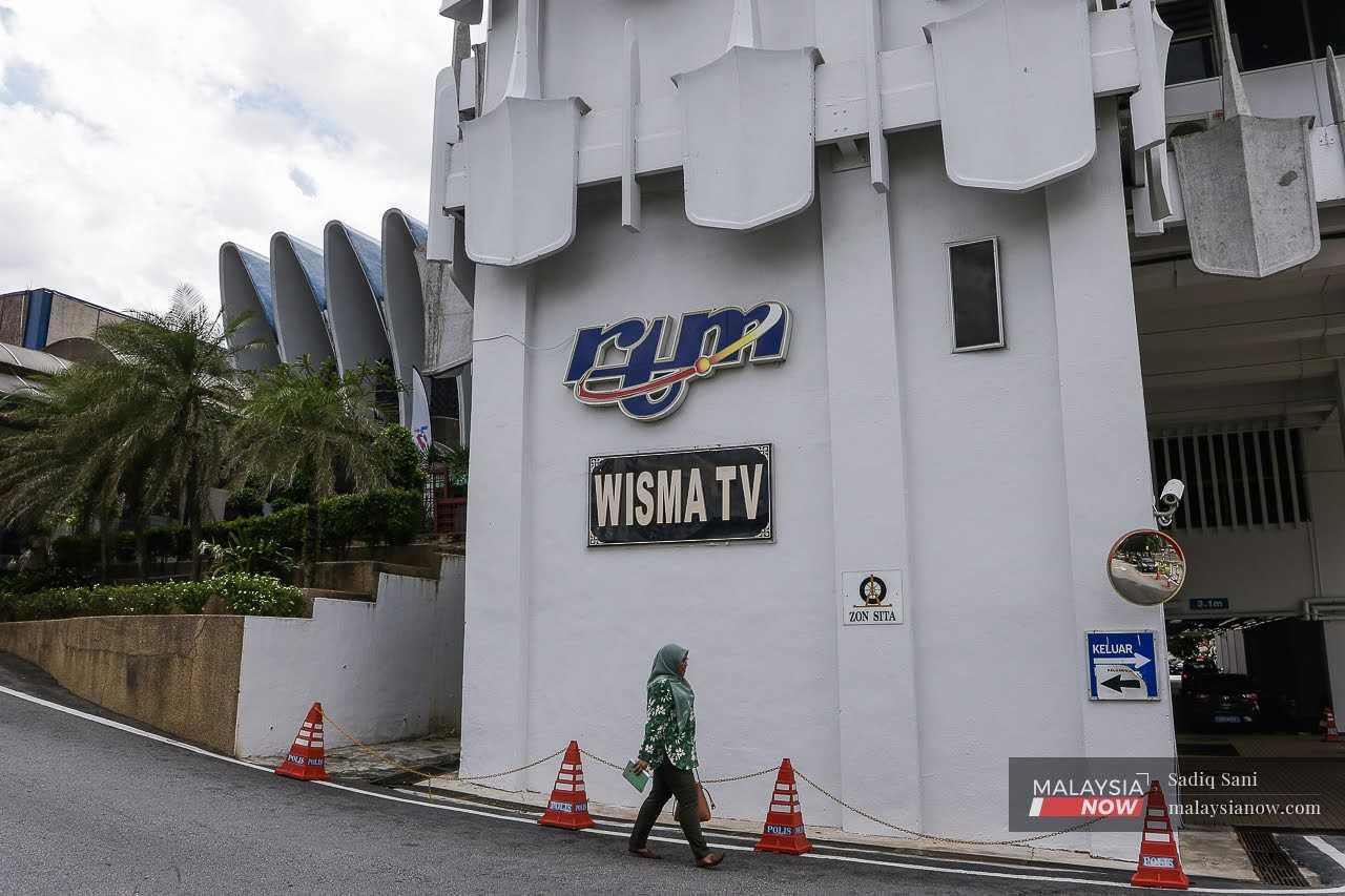 A woman walks past the Radio Televisyen Malaysia headquarters at the Angkasapuri building in Kuala Lumpur.