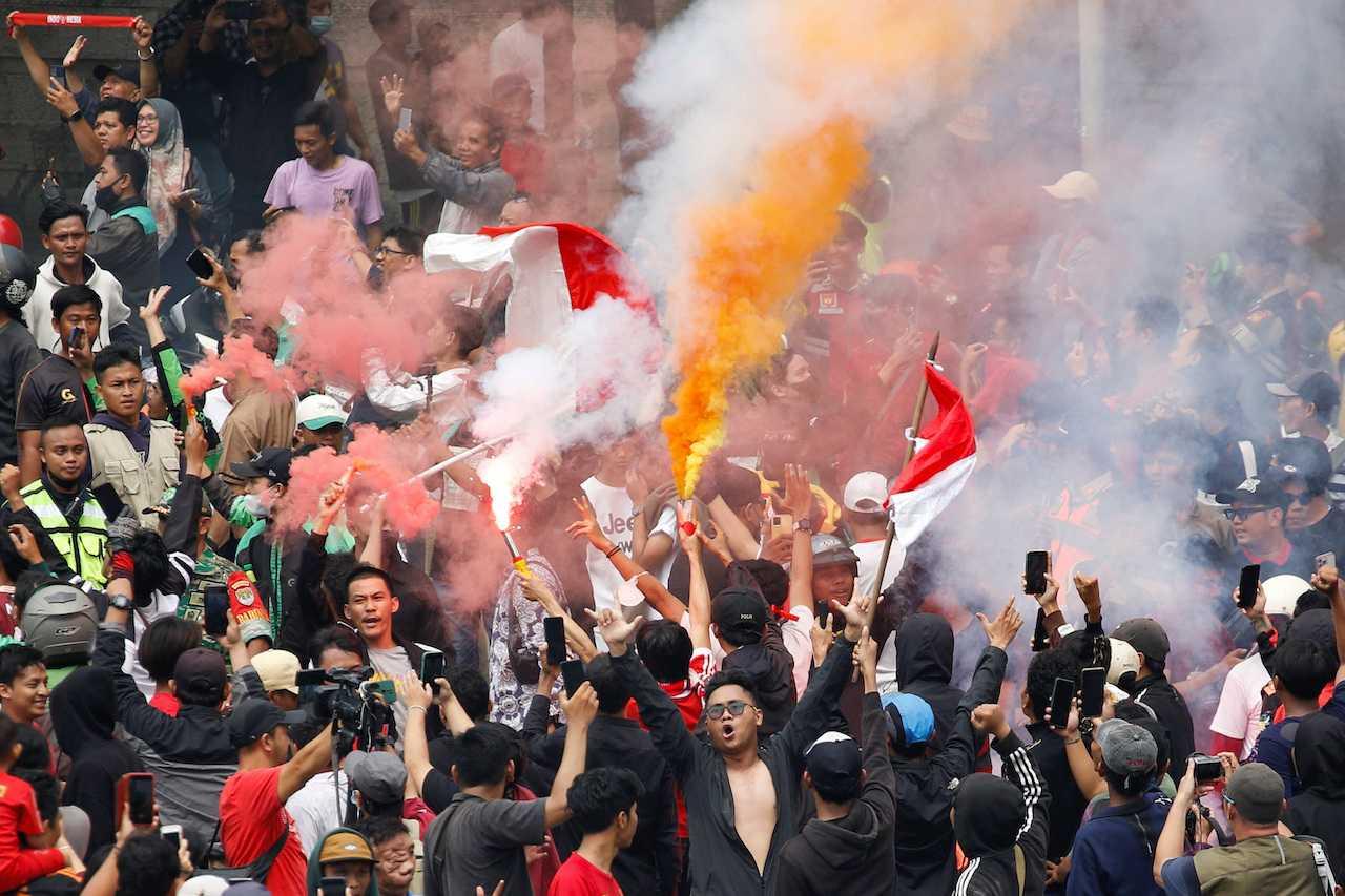 Indonesian football supporters light flares during a parade as they celebrate their football team winning gold at the 2023 SEA Games, in Jakarta, Indonesia, May 19. Photo: Reuters