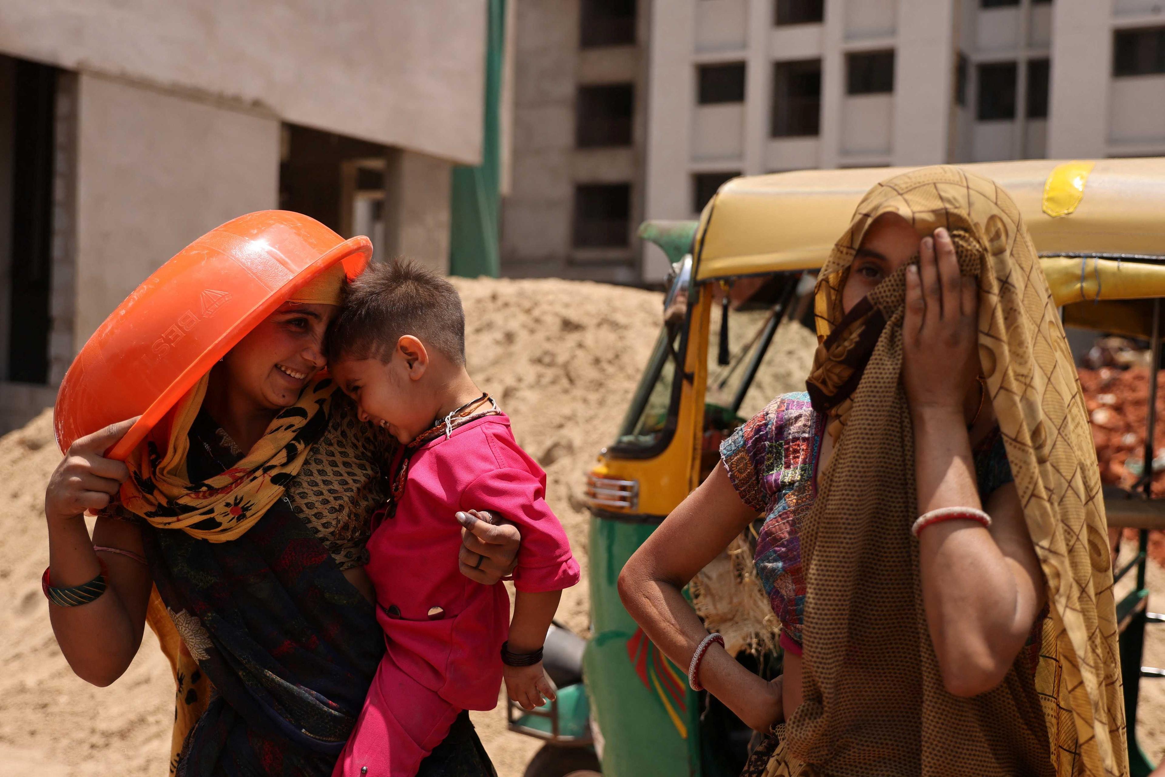 Seorang wanita menggunakan besen bagi melindungi diri dari bahang cahaya matahari di sebuah tapak pembinaan di Ahmedabad, India, 28 April. Gambar: Reuters