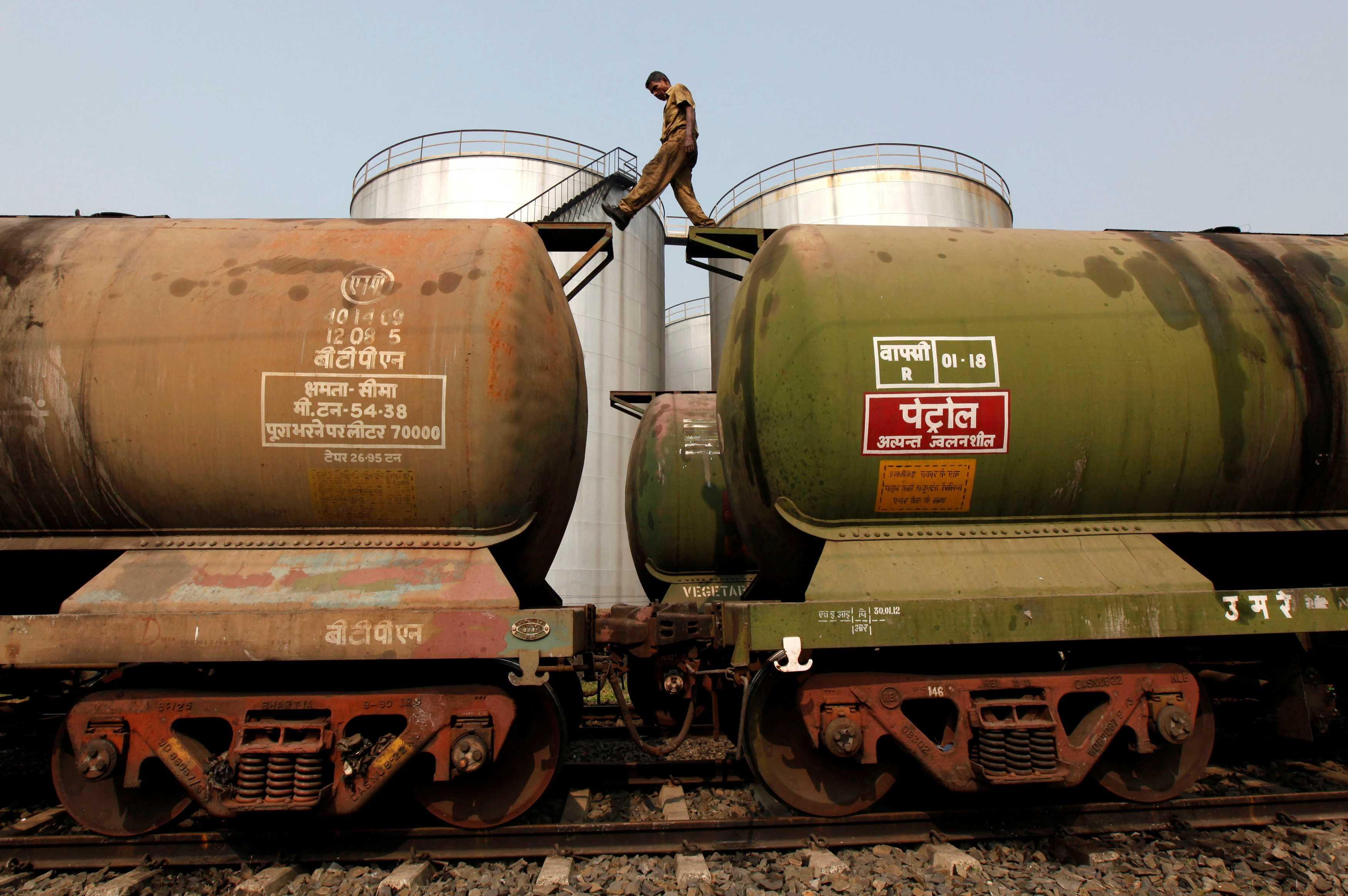 A worker walks atop a tanker wagon to check the freight level at an oil terminal on the outskirts of Kolkata Nov 27, 2013. Photo: Reuters