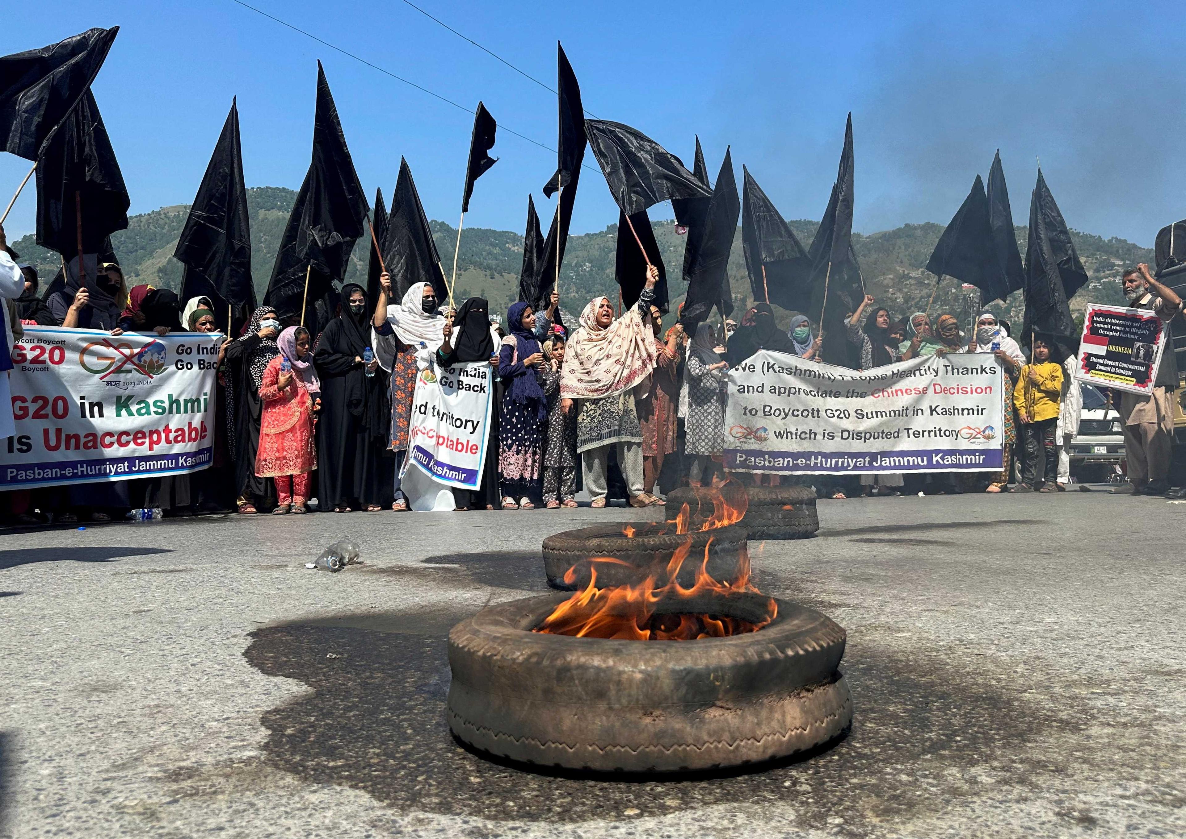 People carry black flags and set tyres ablaze to condemn India's decision to host the G20 Tourism Working Group meeting in Srinagar, during a protest in Muzaffarabad, Pakistan-administrated Kashmir, May 22. Photo: Reuters