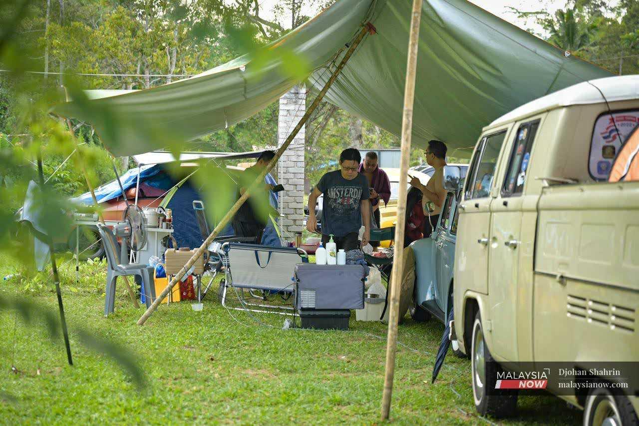 Participants relax at their individual campsites near a Kombi Type 1 and a Beetle. 