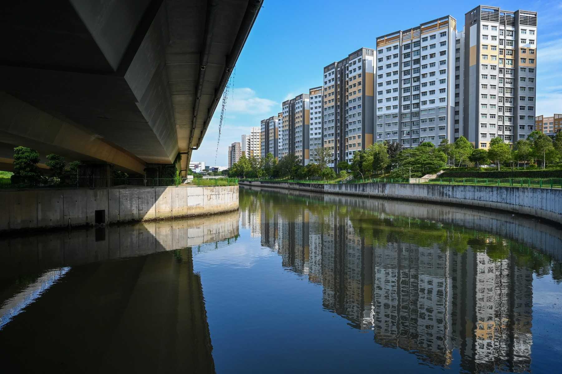 This picture shows public housing flats reflected on the water along the river in Singapore on May 23. Photo: AFP 