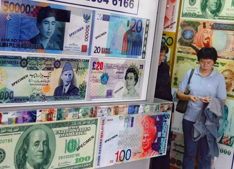 A customer counts her change at a money exchange shop in downtown Kuala Lumpur, Oct 26, 2006. Photo: AFP
