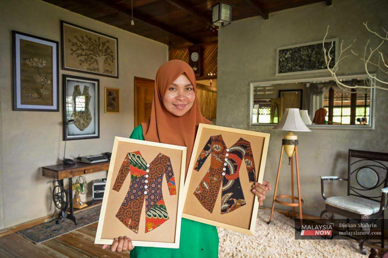 Rafidah memegang beberapa karya seninya yang menunjukkan kebaya yang diperbuat daripada kain perca batik. 