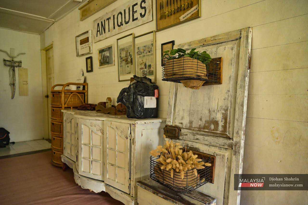 A shelf fashioned out of motorcycle baskets and an old door leans against the wall in a corner of the house.