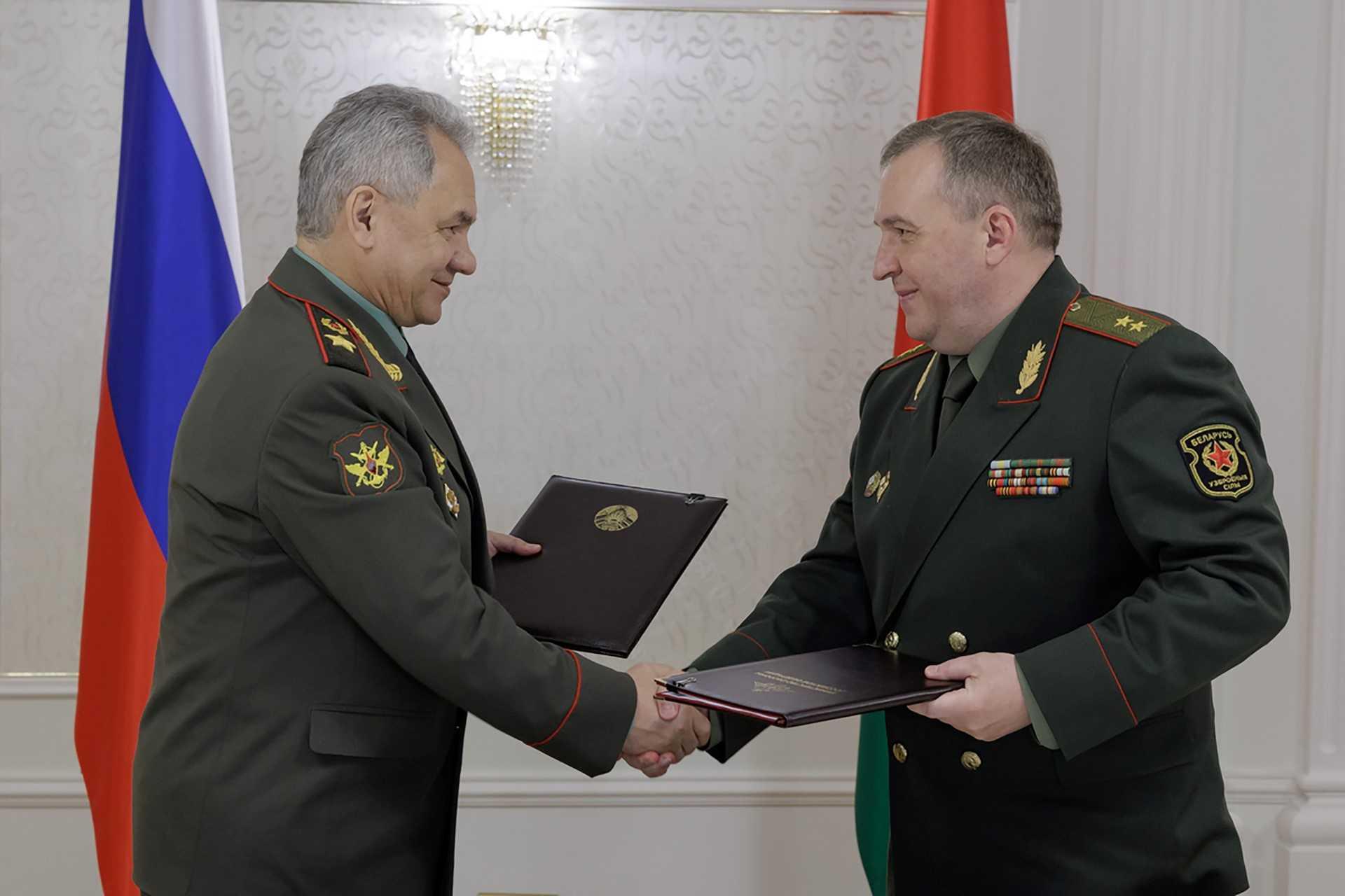 Russian Defence Minister Sergei Shoigu and his Belarusian counterpart Viktor Khrenin shake hands after signing an agreement on the deployment of Russia's nuclear-capable weapons in Belarus, in Minsk on May 25. Photo: AFP