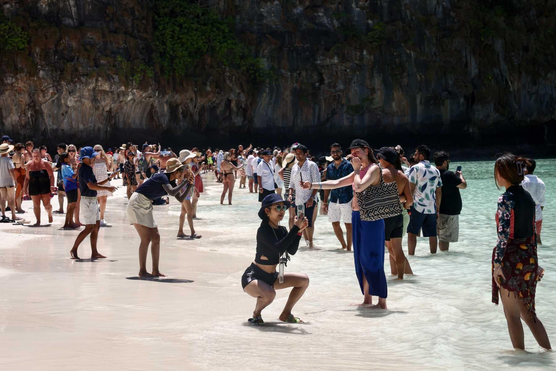 Tourists gather along the beach and take pictures at Maya Bay on Thailand's Phi Phi Leh island on March 17. Photo: AFP 