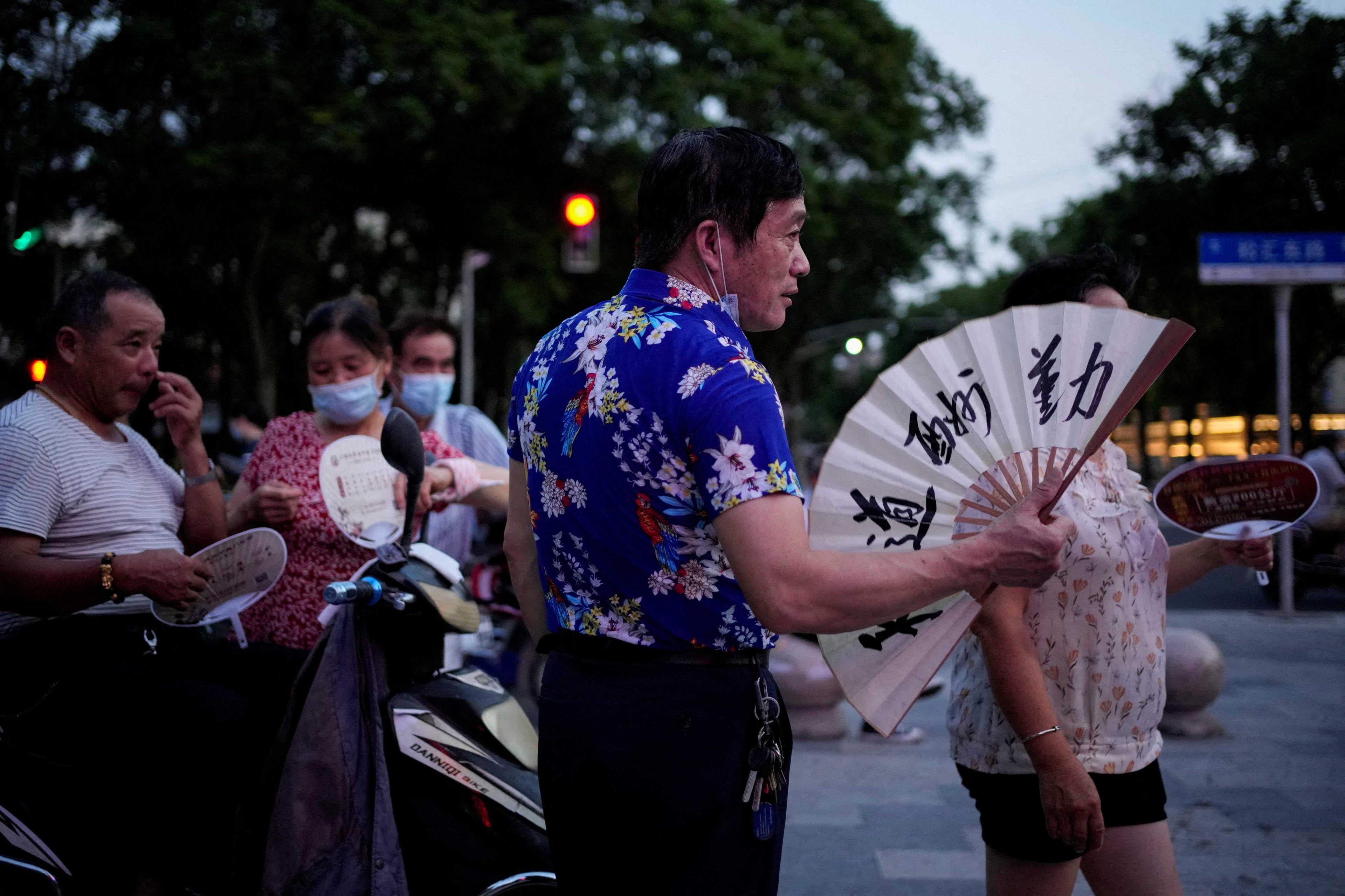 People use fans as they gather in a park amid a heatwave warning in Shanghai, China July 23, 2022. Photo: Reuters