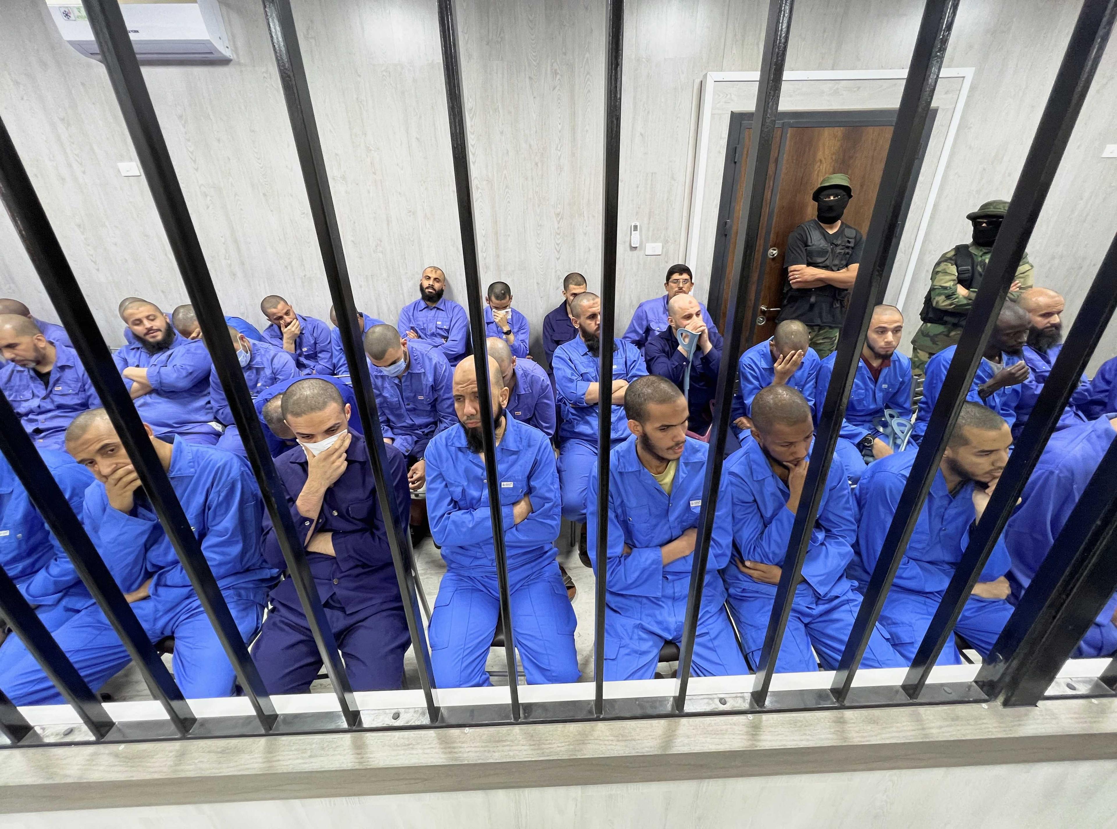 Suspects sit behind bars during a judgment sentence against 56 defendants accused of joining Islamic State group in the court in Misrata, Libya, May 29. Photo: Reuters