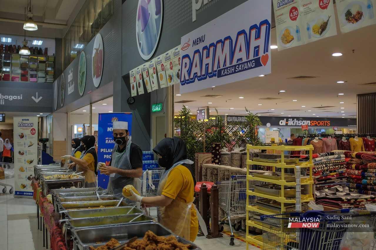 Pekerja membungkus makanan ke dalam beg plastik untuk dijual di bawah program Menu Rahmah yang diperkenalkan kerajaan.
