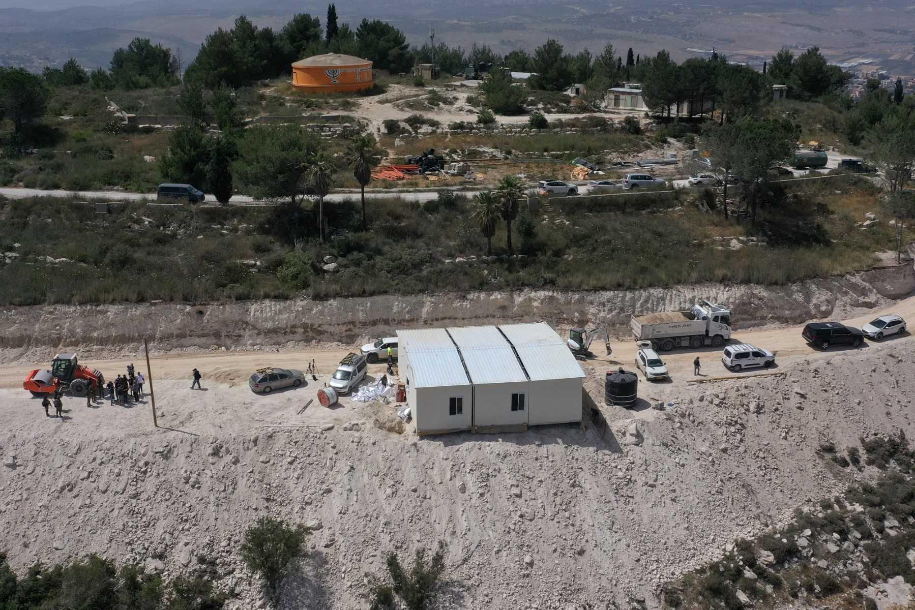 An aerial view shows people around a portable building under construction at the Israeli settler outpost of Homesh, near the Palestinian village of Burqah, in the occupied West Bank, May 29. Photo: AFP