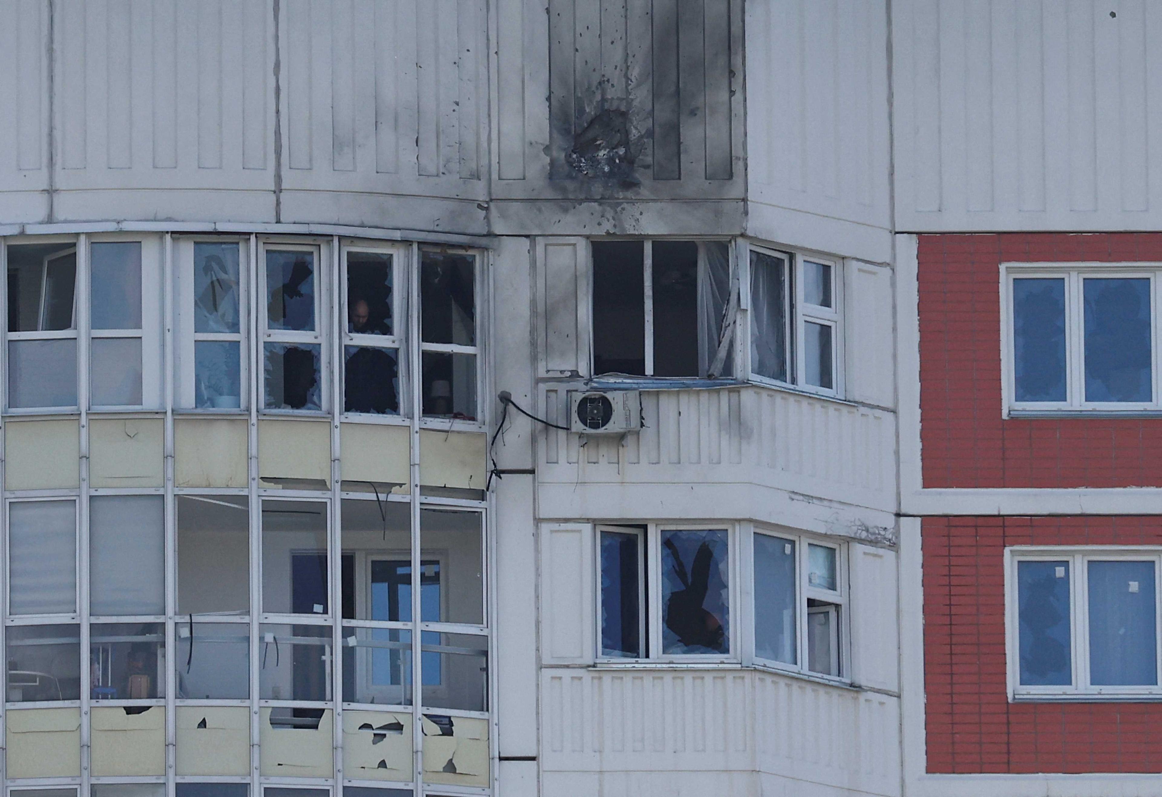 A man is seen through a window of a damaged multi-storey apartment block following a reported drone attack in Moscow, Russia, May 30. Photo: Reuters