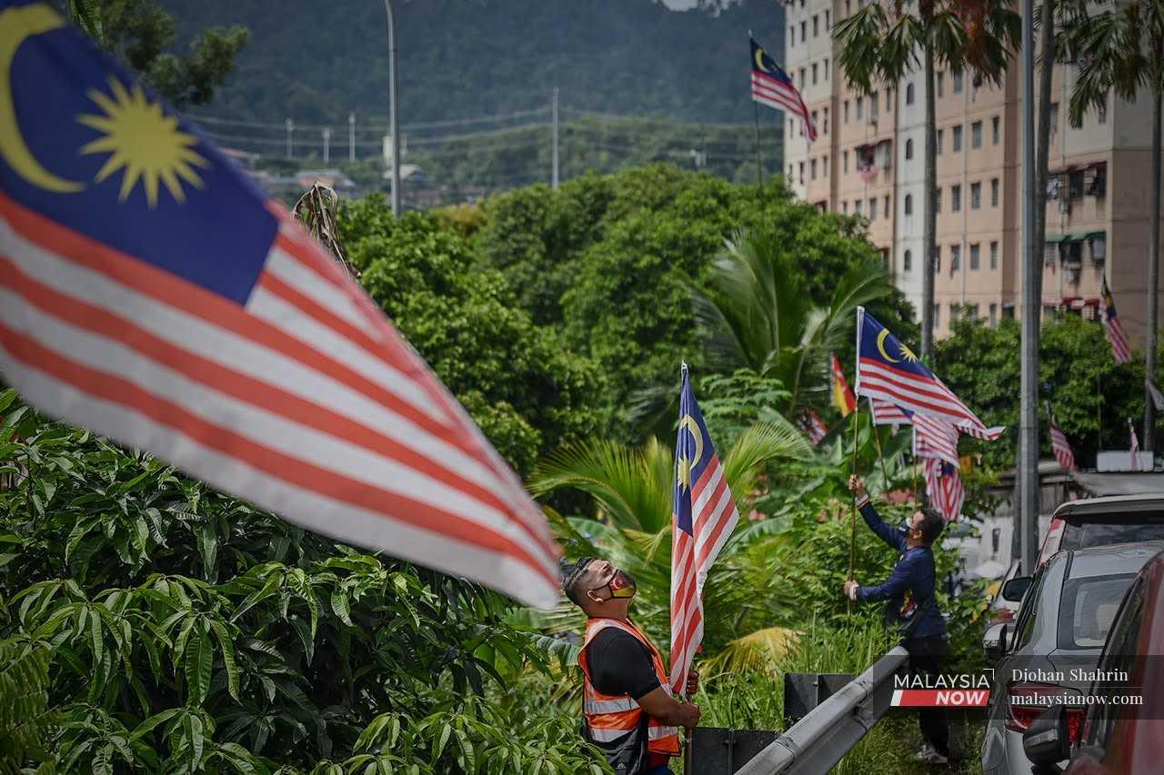 Dua penduduk Pangsapuri Taman Industri Lembah Jaya, menyemarakkan semangat kebangsaan dengan memasang bendera Malaysia di kawasan parkir kenderaan berhampiran kediaman mereka di Lembah Jaya, Ampang.