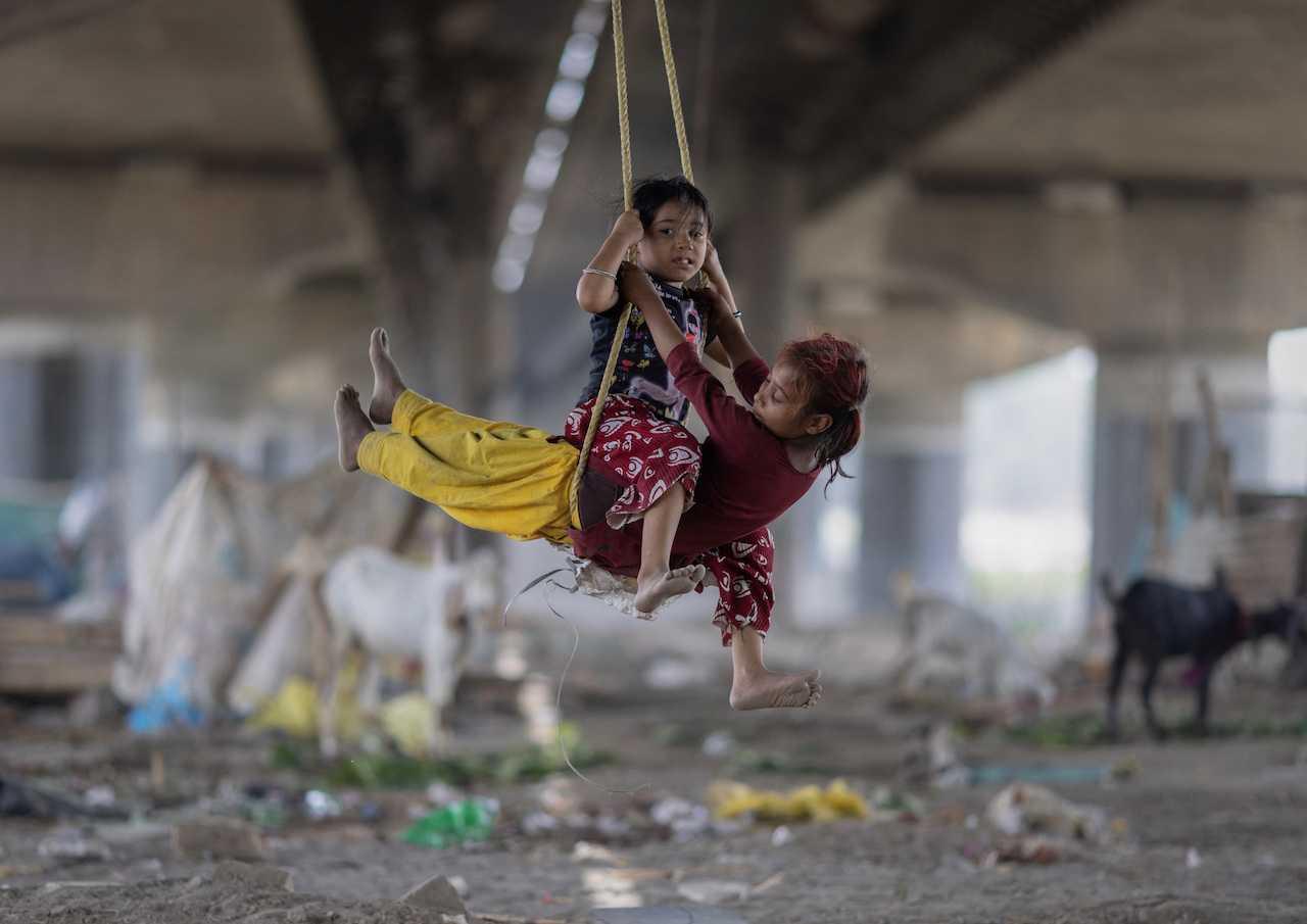 Girls play on a swing under a bridge on a hot summer day in New Delhi, India. Photo: Reuters
