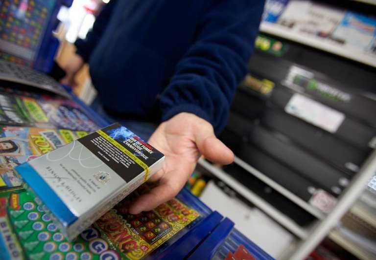 A corner store owner in Ontario, Canada, holds a package of cigarettes on March 12, 2012. Photo: AFP