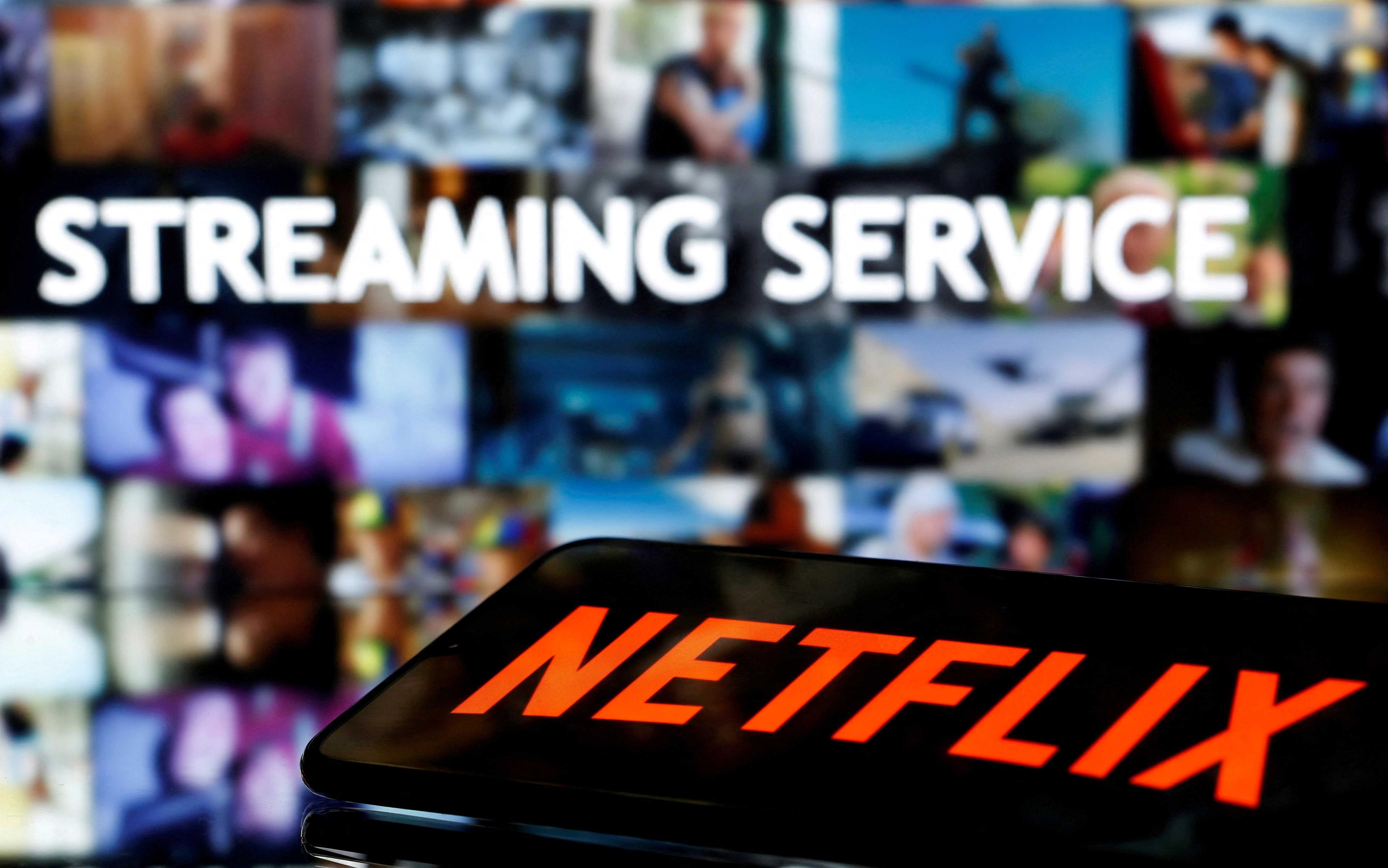 Sebuah telefon pintar dengan logo Netflix terletak di hadapan perkataan 'Perkhidmatan penstriman' yang dipaparkan dalam ilustrasi yang diambil pada 24 Mac 2020. Gambar: Reuters