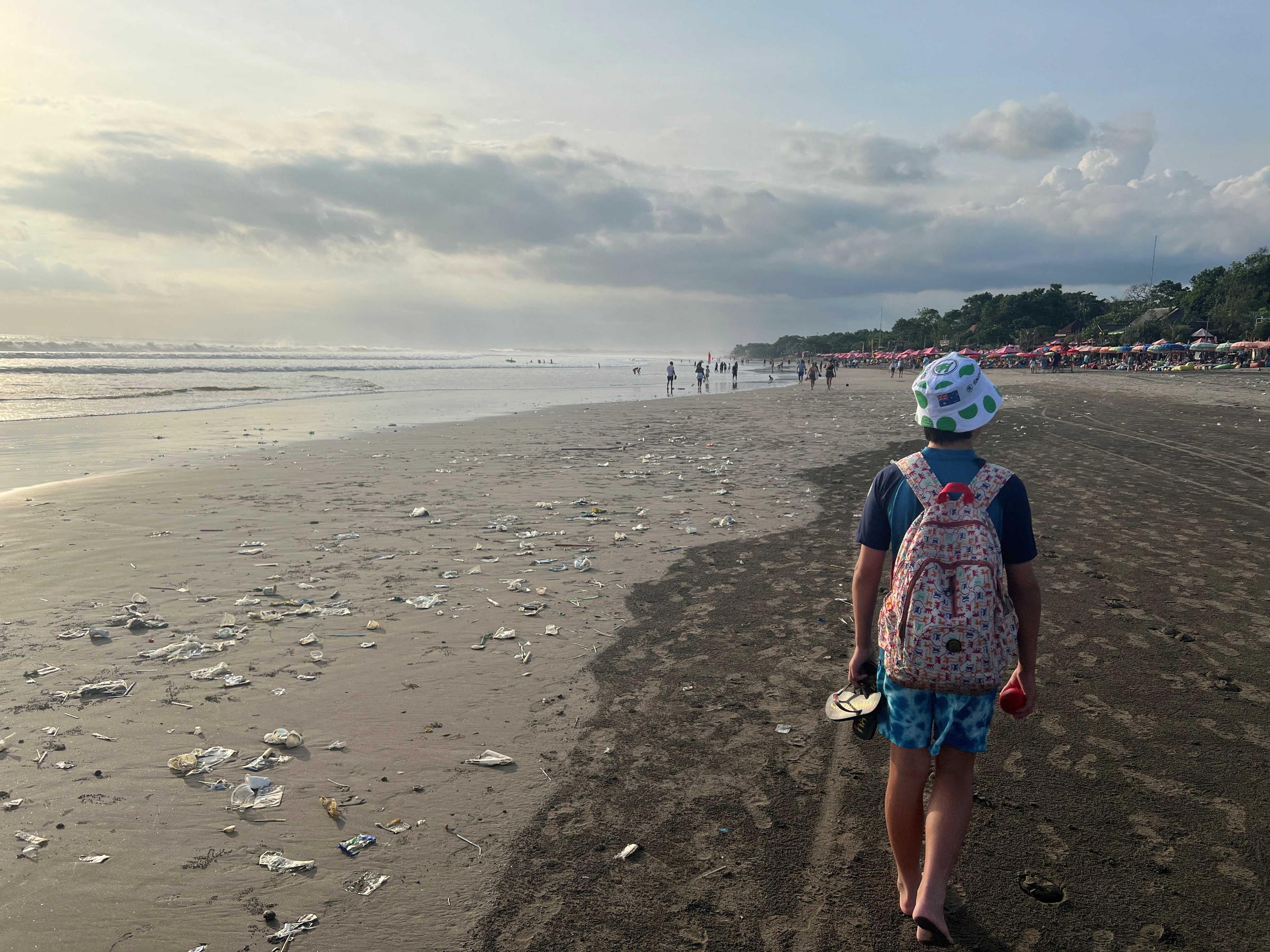 Seorang kanak-kanak lelaki berjalan di pantai yang dipenuhi sampah plastik di Bali, Indonesia, 17 April. Gambar: Reuters