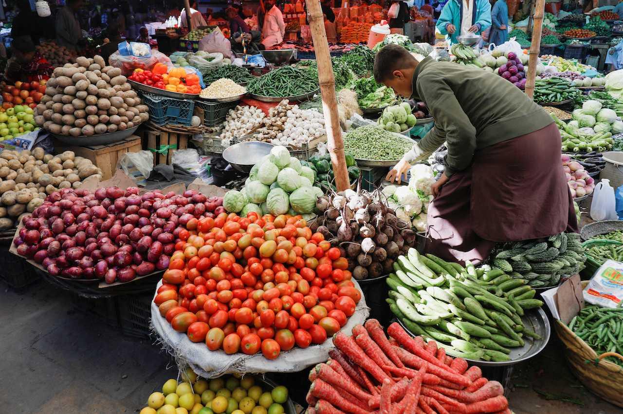 A boy buys vegetables from a makeshift stall at a market in Karachi, Pakistan. Photo: Reuters