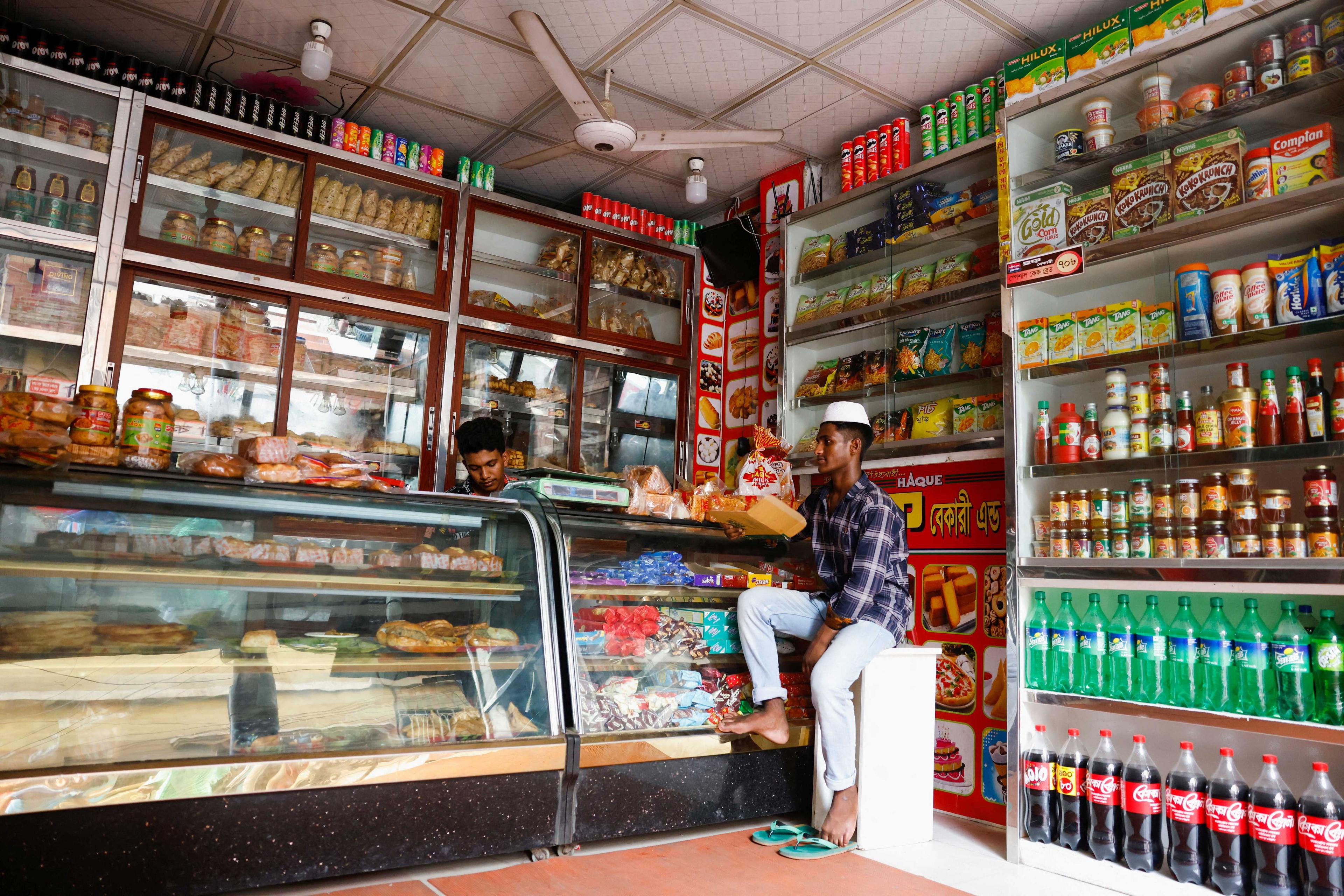 People in a shop sit idly as there is no electricity during a countrywide heatwave, in Dhaka, Bangladesh, June 6. Photo: Reuters